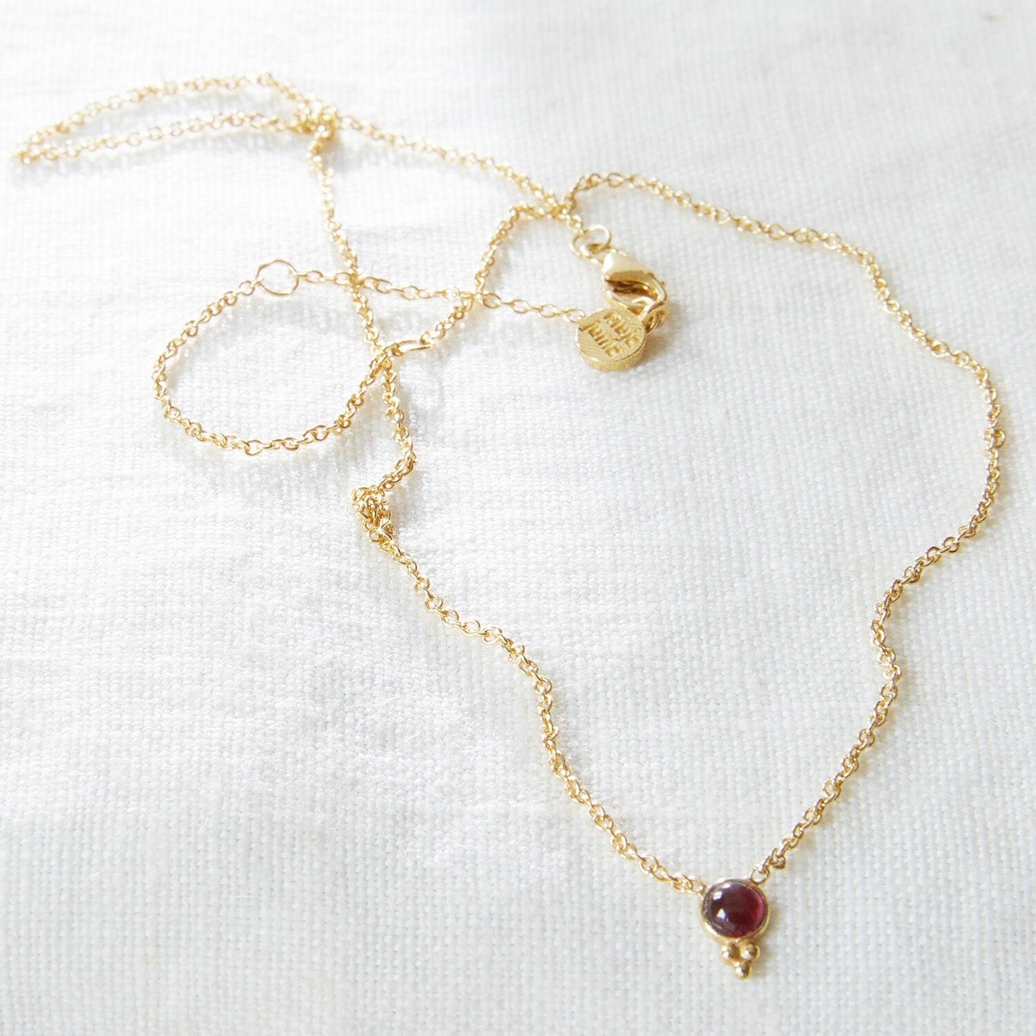 Feine goldene Halskette mit rotem Stein an zartem Kettchen, eleganter Damenschmuck