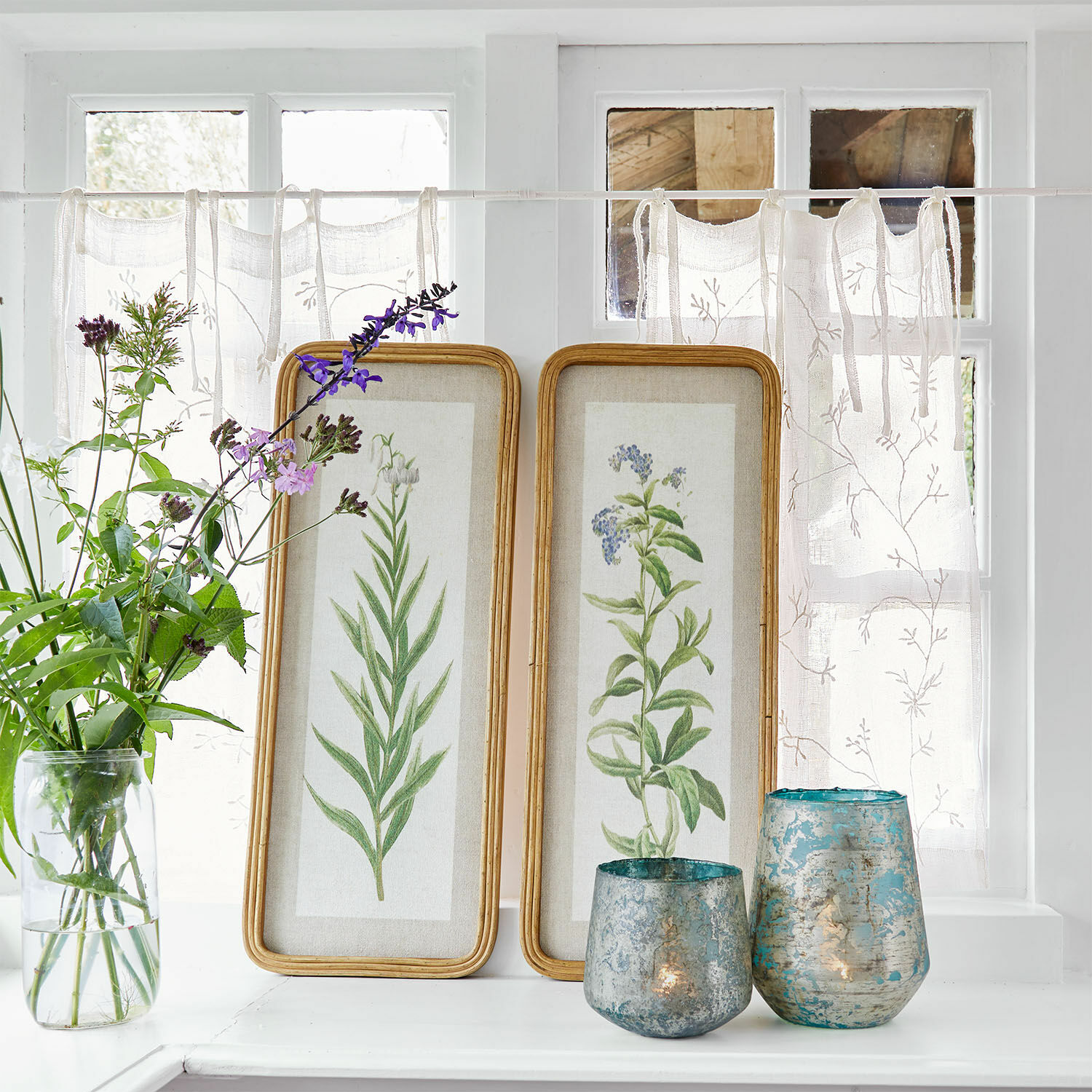 Bild 2er Set Cenori Zwei Holzrahmen mit botanischen Pflanzenillustrationen auf weissem Fensterbrett mit blauen Dekokerzenhaltern