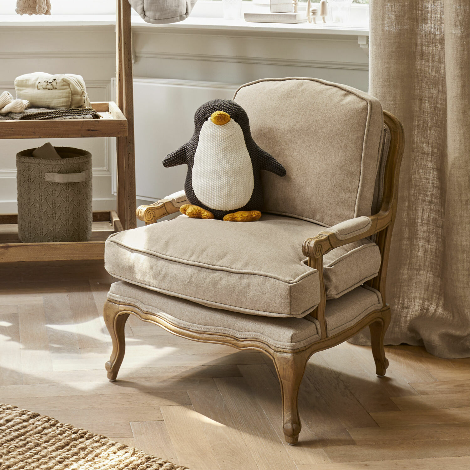 Kindersessel Orlianne Beiger Polsterstuhl mit Holzrahmen und weichem Kissen, dekoriert mit gestricktem Pinguin.