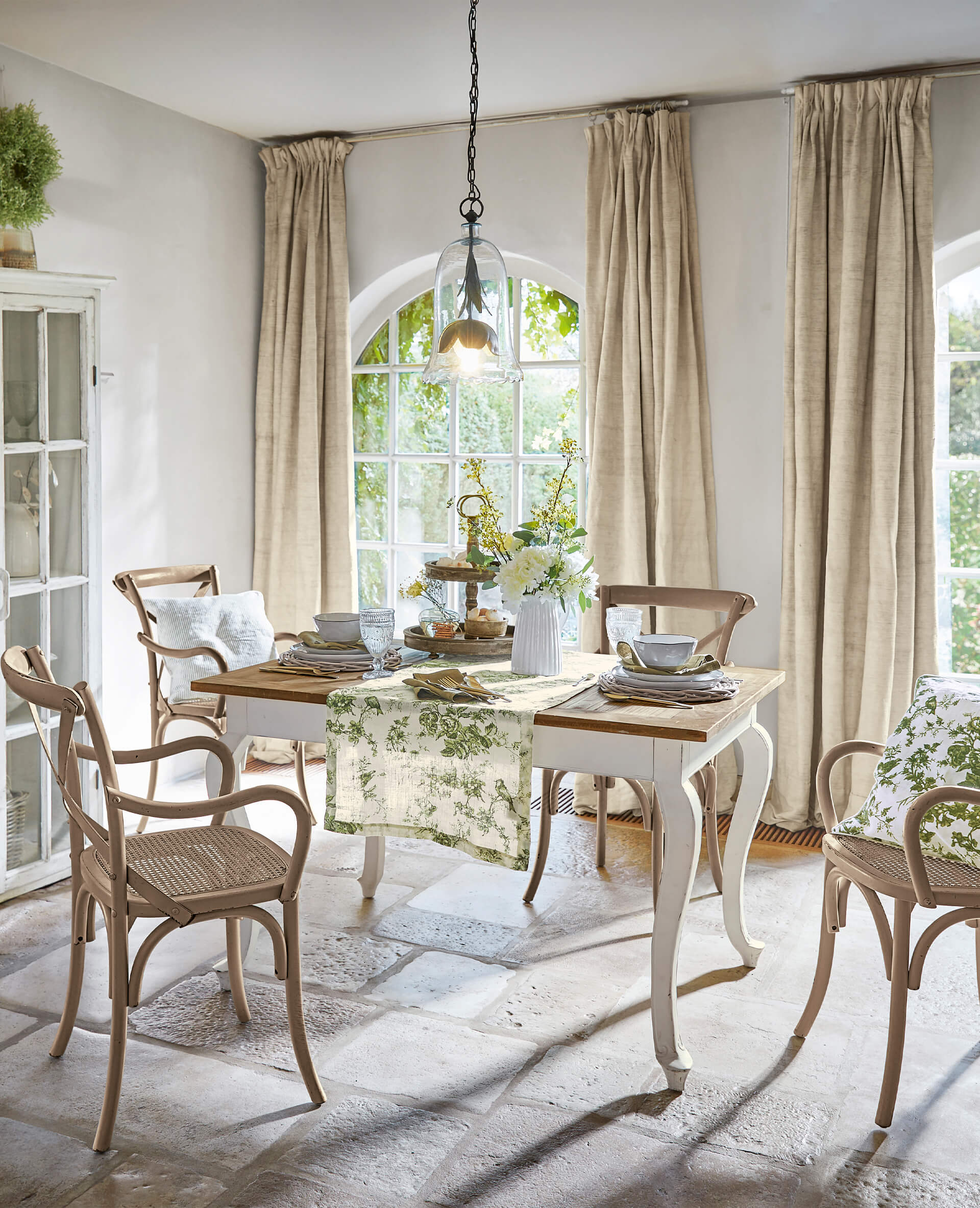 Esszimmer mit Holztisch und beigen Stühlen, grüner Tischläufer mit floralem Muster