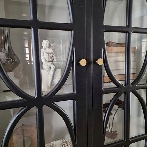 Schwarzer Metallschrank mit dekorativen Glastüren und goldenen Griffen, Dekoration innen