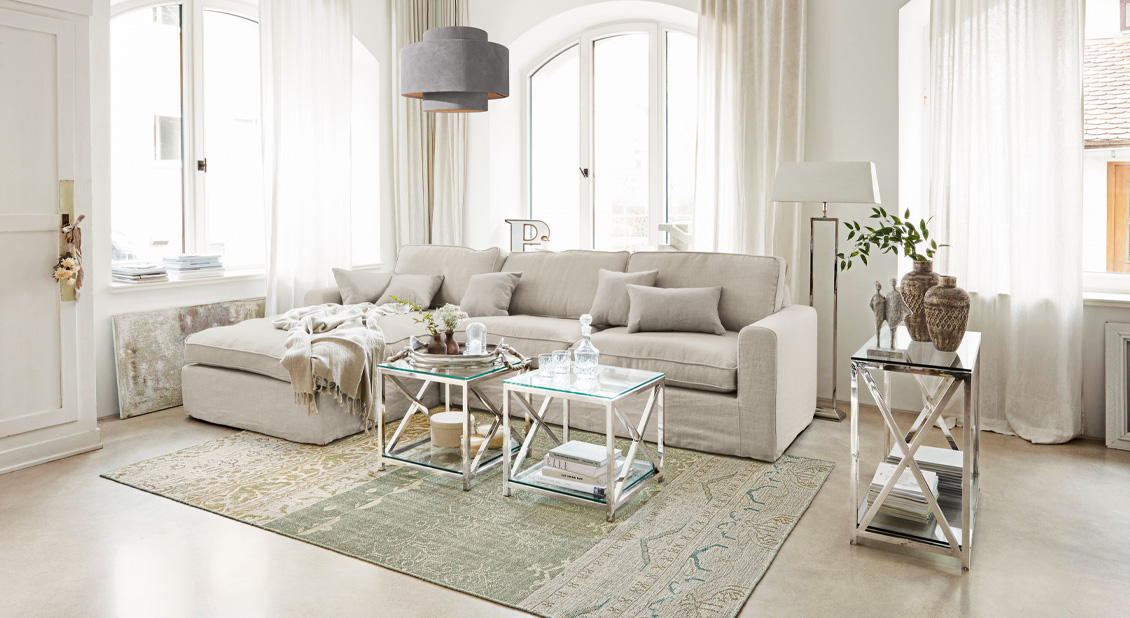 Beiges Sofa im Leinen-Look mit Kissen und Metalltischen in hellem Wohnzimmer