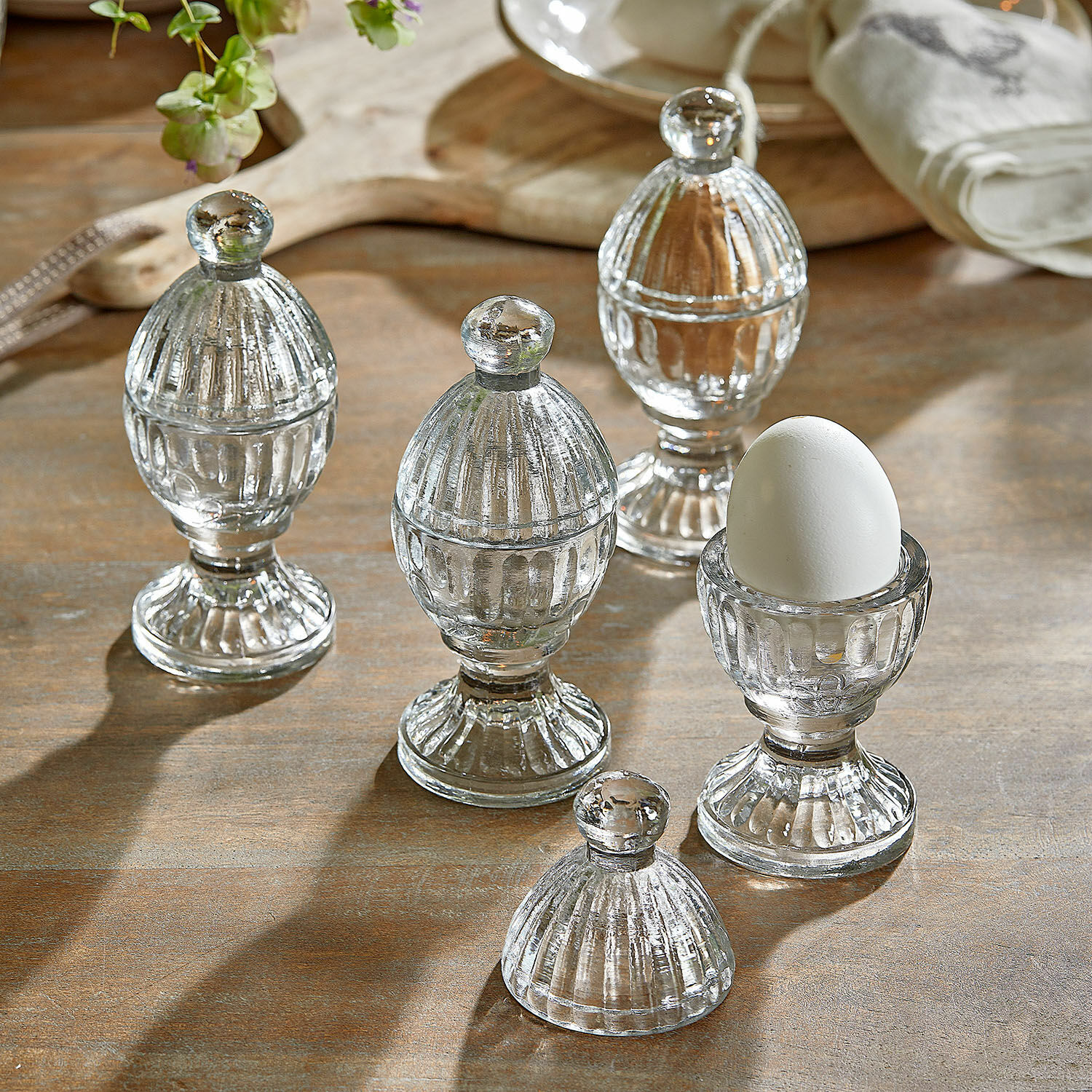 Eierbecher 4er Set Uvirel Transparente Glas-Eierbecher mit Deckeln auf Holztisch zur Küchendekoration
