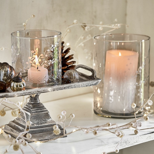 Glaswindlichter mit weissen Kerzen auf Metallständern im rustikalen Stil, festliche Dekoration