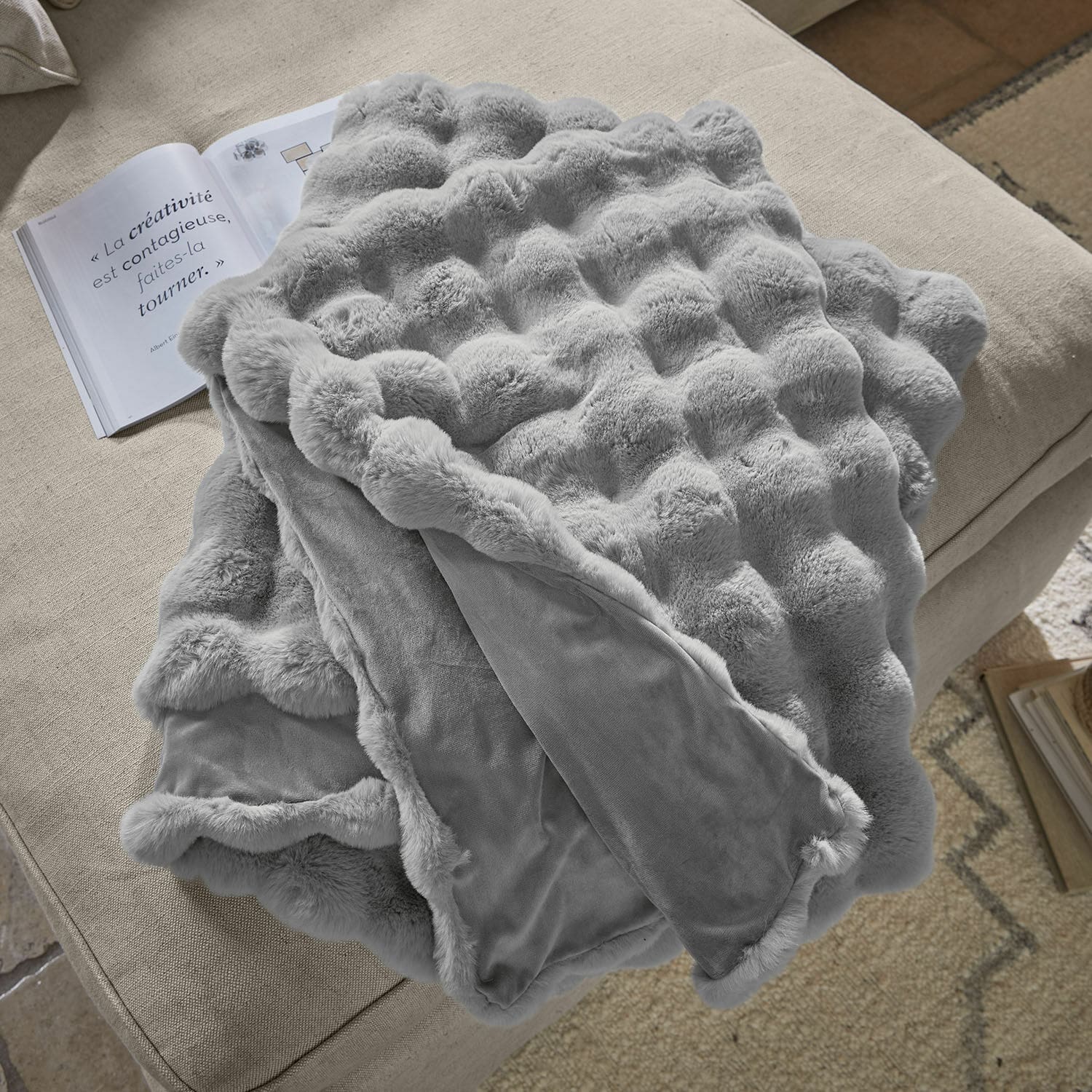 Plaid Zalina Weiche graue Kuscheldecke mit Fellmuster auf beigem Sofa, ideal zur Dekoration und zum Wärmen