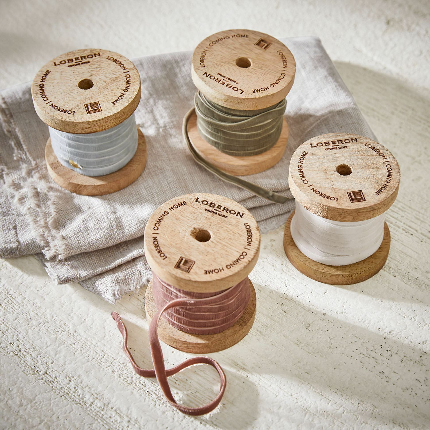 Samtband 4er Set Hilary Holzspulen mit samtigen Bändern in Pastellfarben auf Leinenstoff, dekoratives Wohnaccessoire