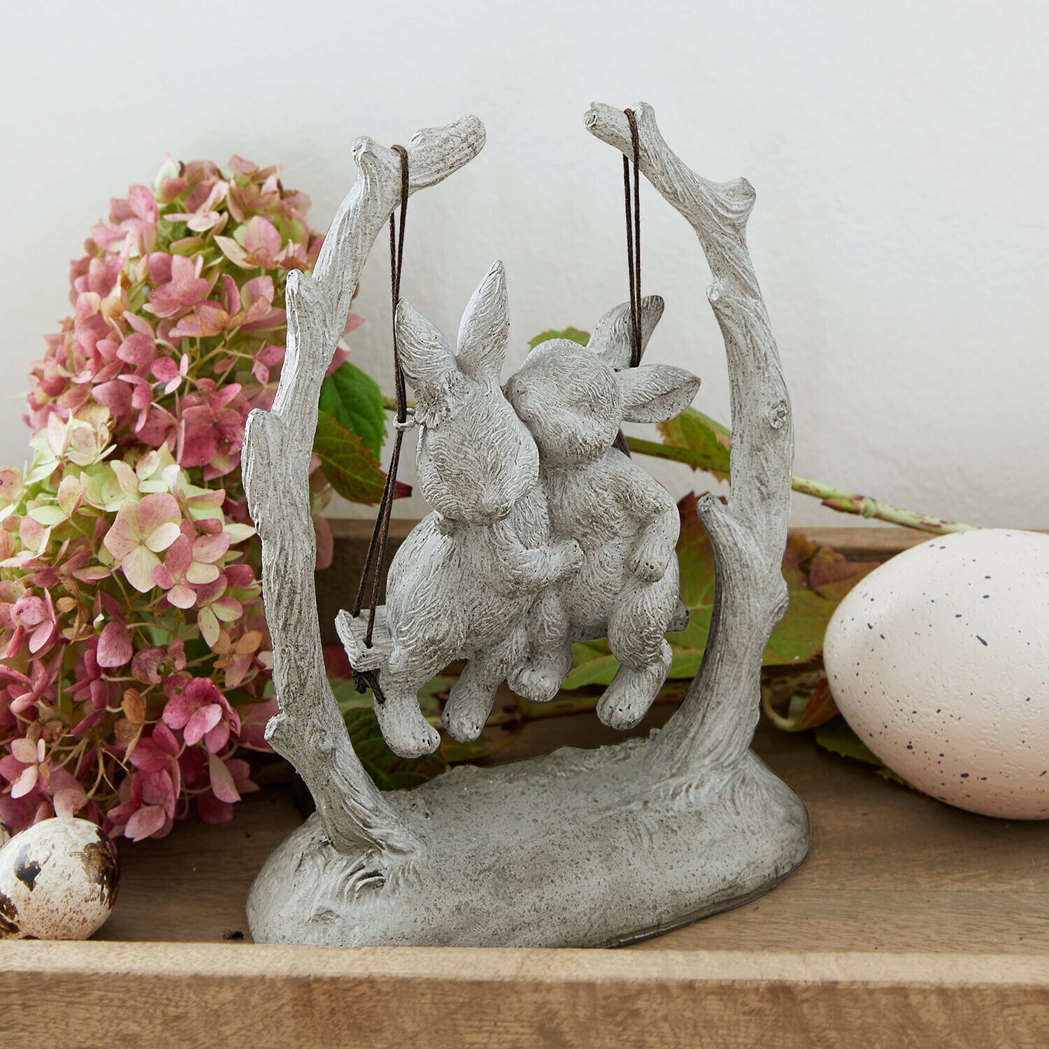 Hasen Nivelles Graue Steinskulptur mit zwei Hasen auf Schaukel, dekorative Osterfigur
