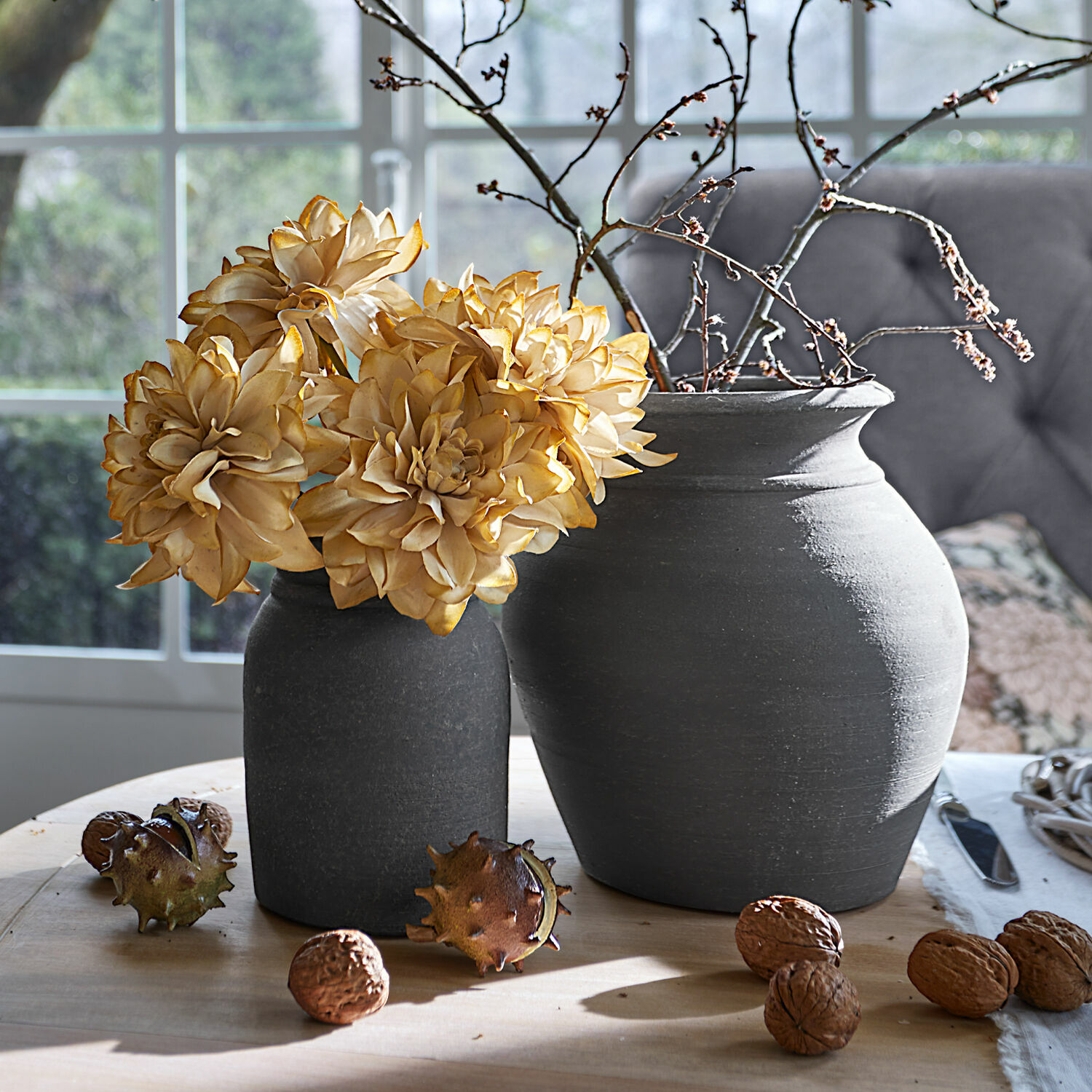 Deko-Blume 4er Set Cappellina Zwei dunkelgraue Keramikvasen mit getrockneten Blumen und Nüssen auf hellem Holztisch