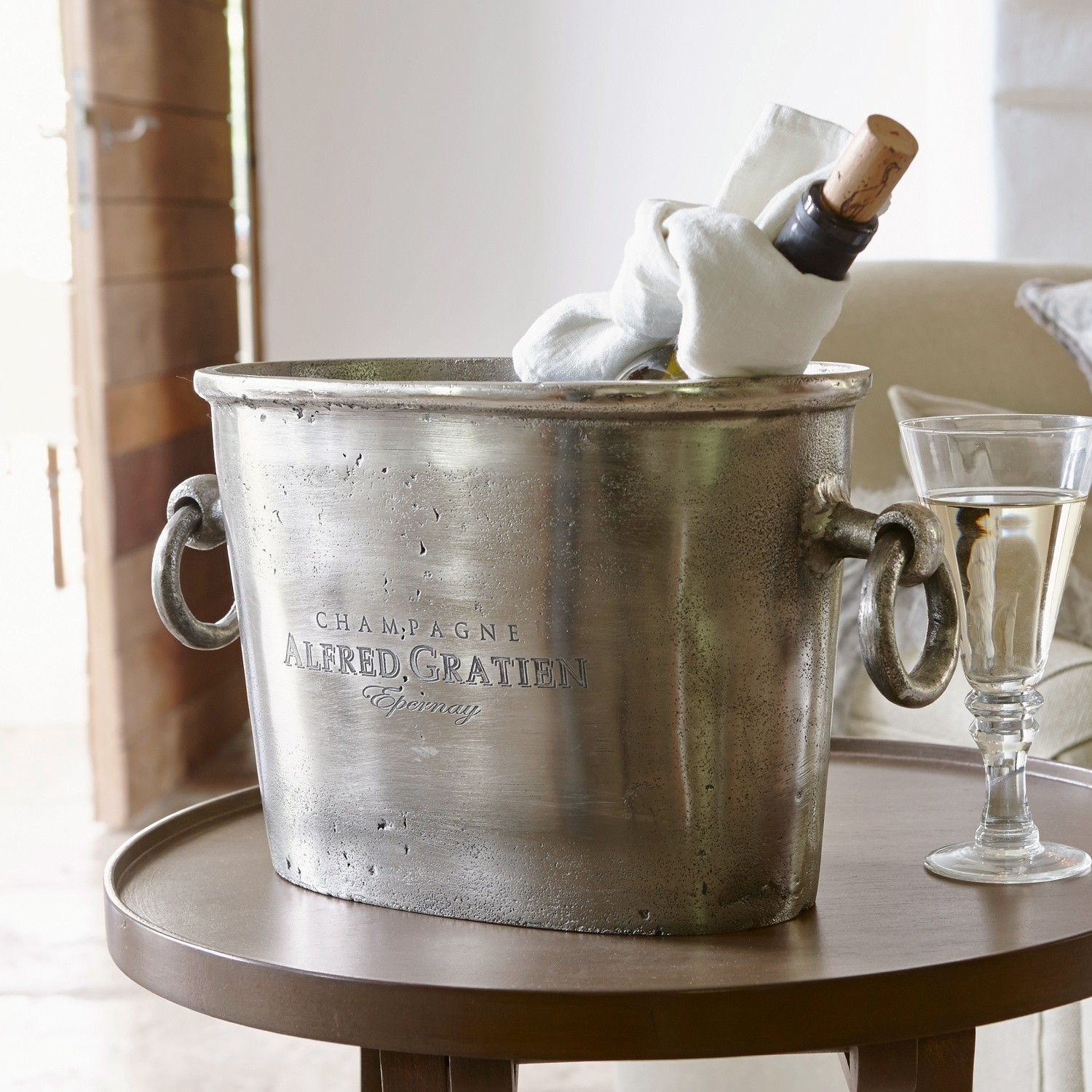 Sektkühler Alfred Metall-Champagnerkühler in Silber mit Griffen und Flasche auf rundem Tisch