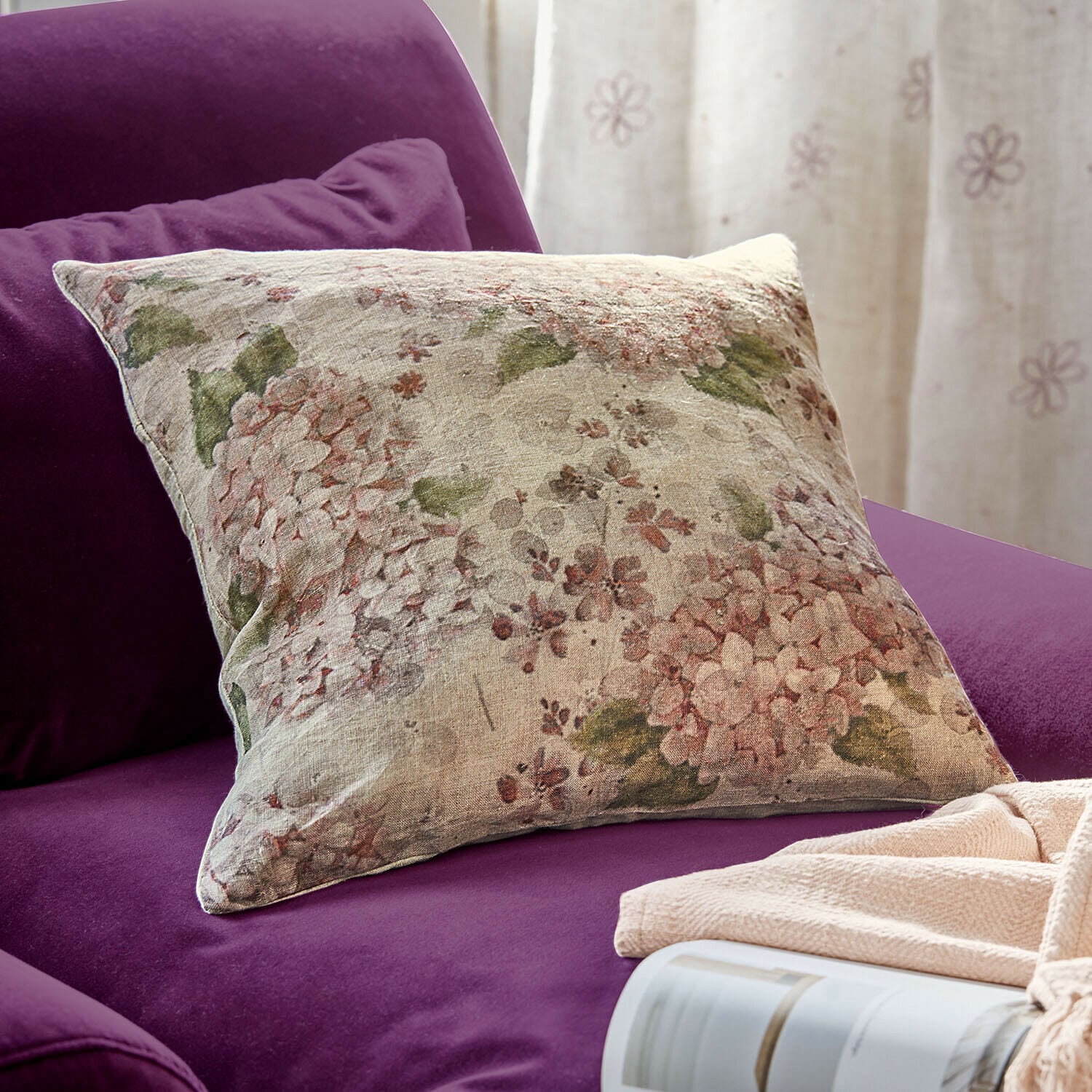Kissenhülle Amélorie Dekoratives Leinenkissen mit Blumenmuster auf violettem Sofa, gemütliches Wohnaccessoire
