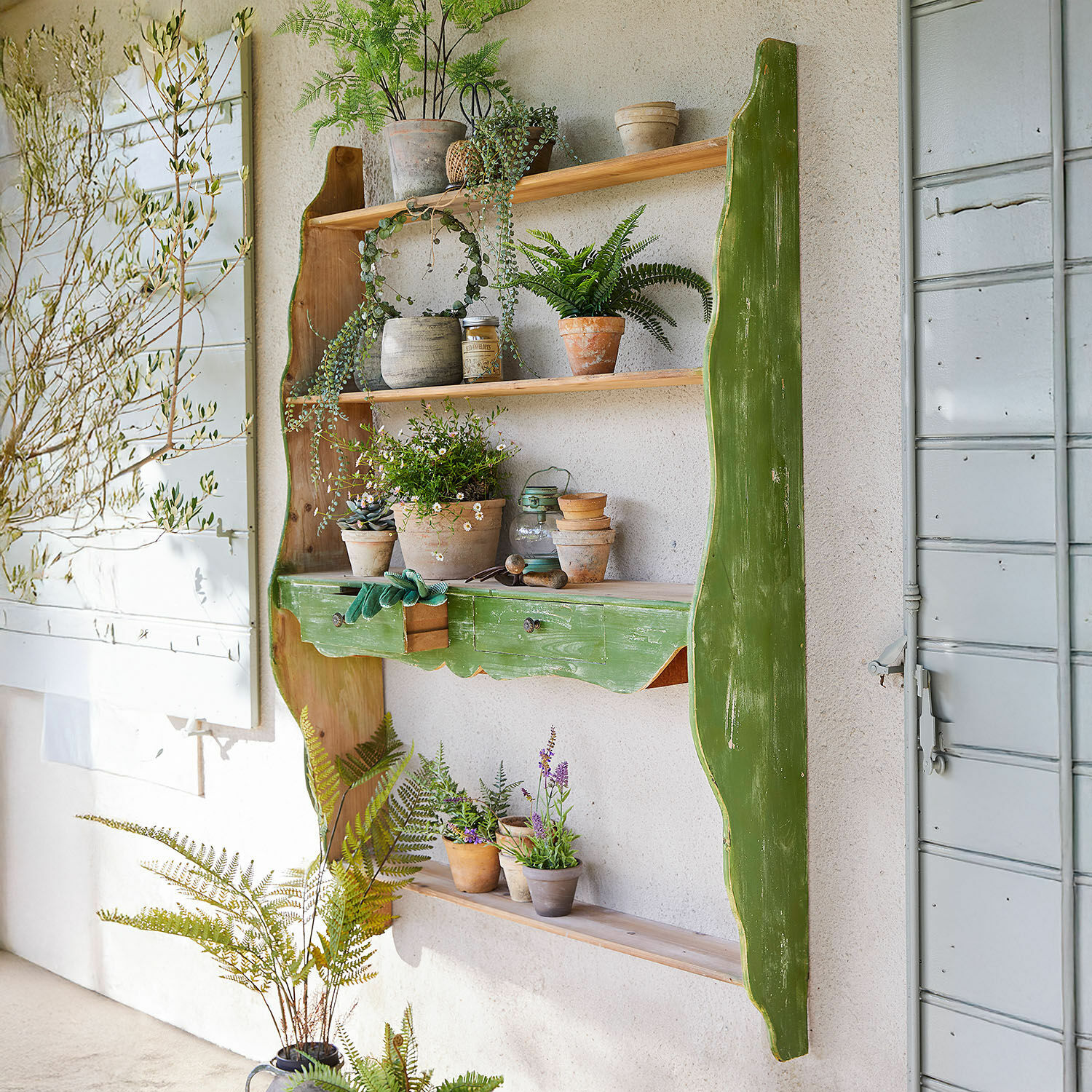 Rustikales grünes Holz-Wandregal mit Blumentöpfen und Gartengeräten zur Wohnraumdekoration