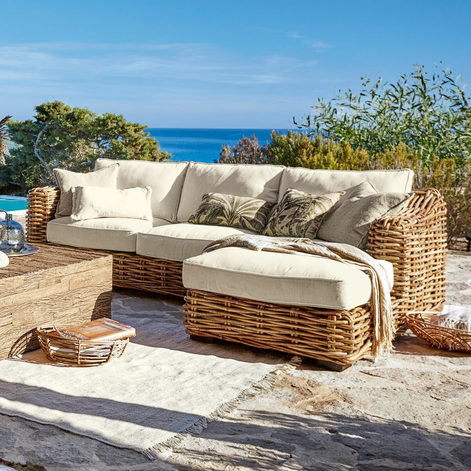 Sofa Villedieu Ecksofa aus Rattan mit cremefarbenen Kissen auf der Terrasse mit Meerblick, Gartenmöbel