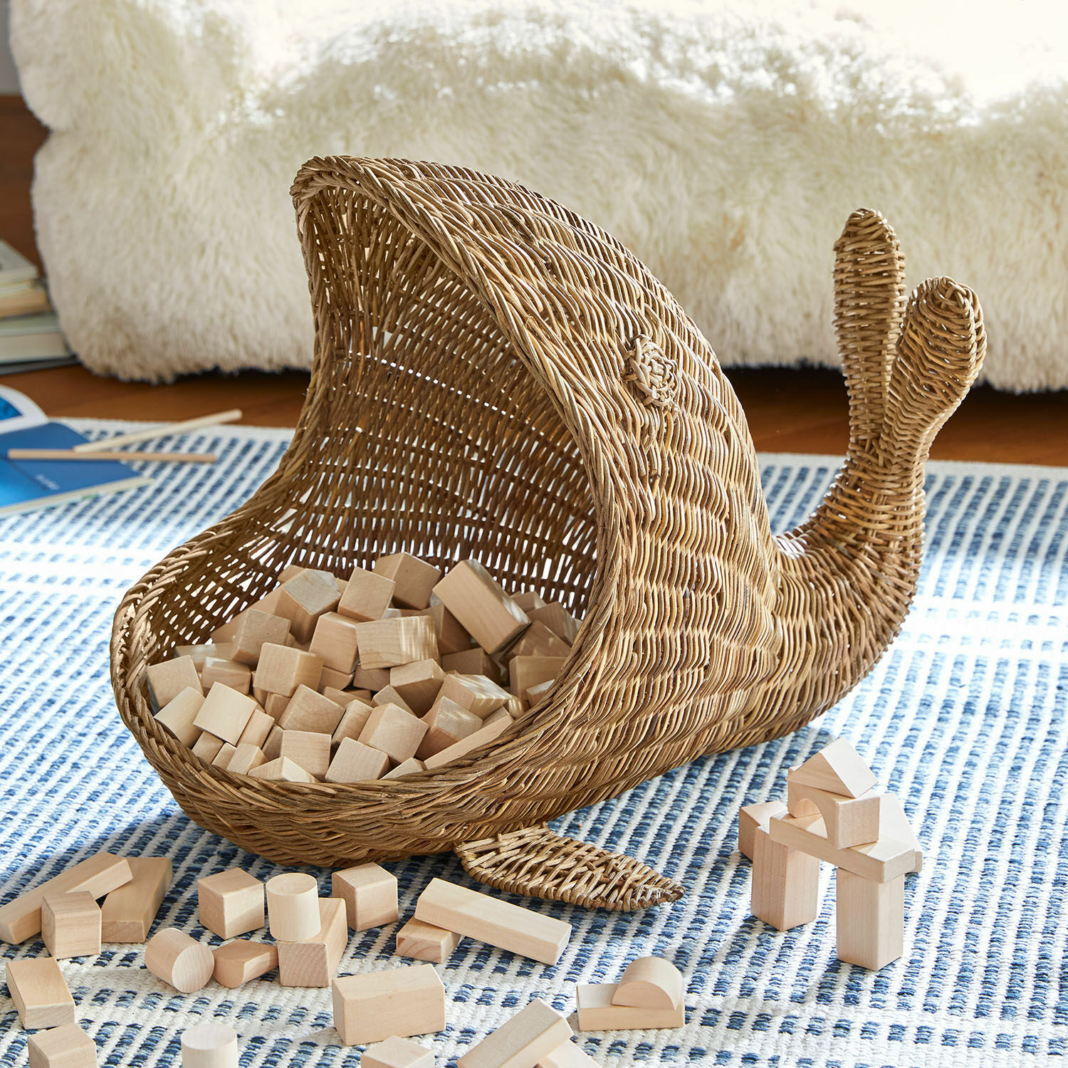 Korb Cheruboo Wikingerkorb in Walform aus Naturweide mit Holzbausteinen auf blau gemustertem Teppich