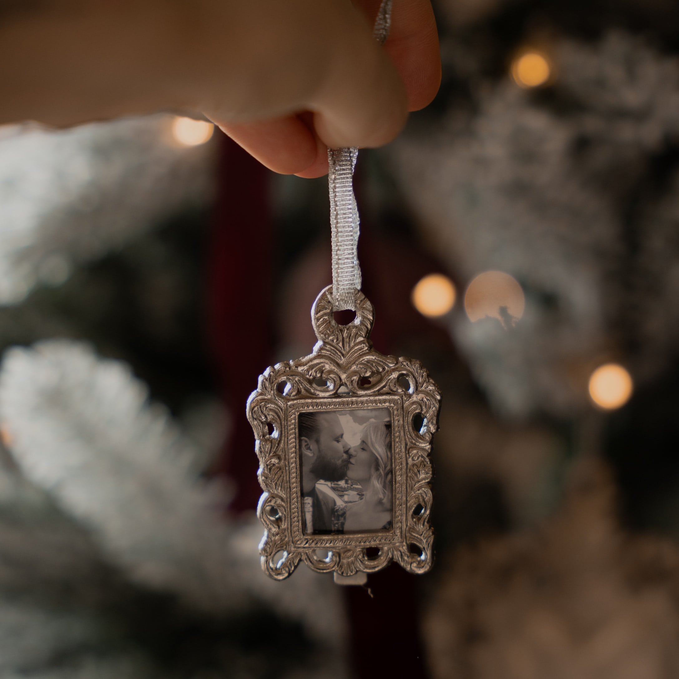 Weihnachtsschmuck mit silbernem Metallrahmen und Schwarz-Weiss-Foto eines sich küssenden Paares
