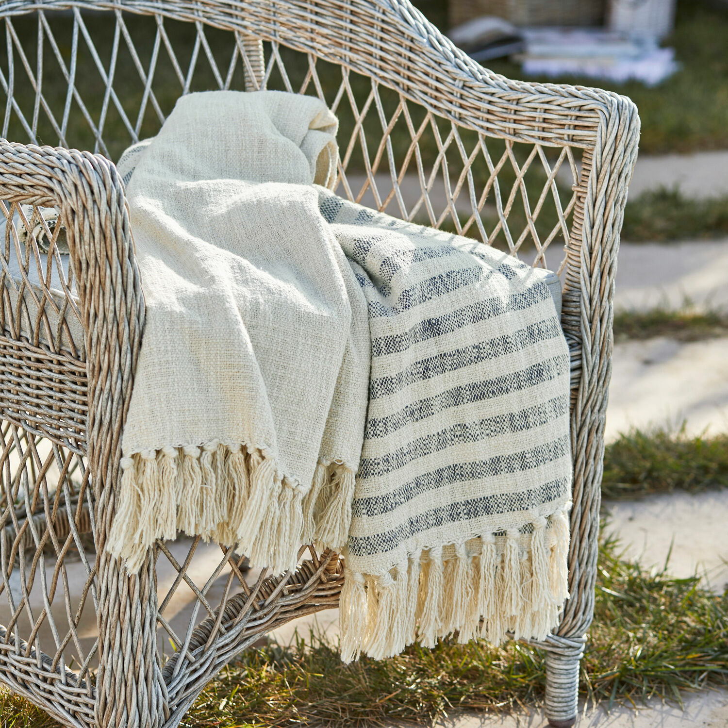 Plaid Marpent Beige Baumwolldecke mit Fransen auf einem Rattansessel im Garten, gemütliche Dekoration