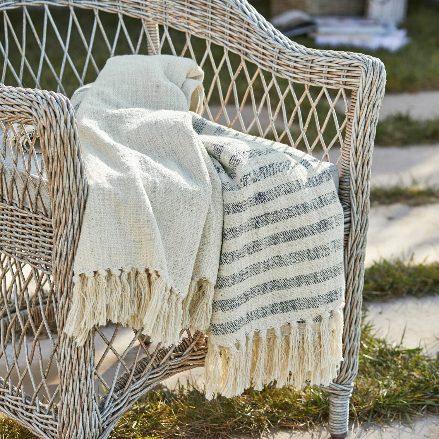 Plaid Marpent Beige Baumwolldecke mit Fransen auf einem Rattansessel im Garten, gemütliche Dekoration