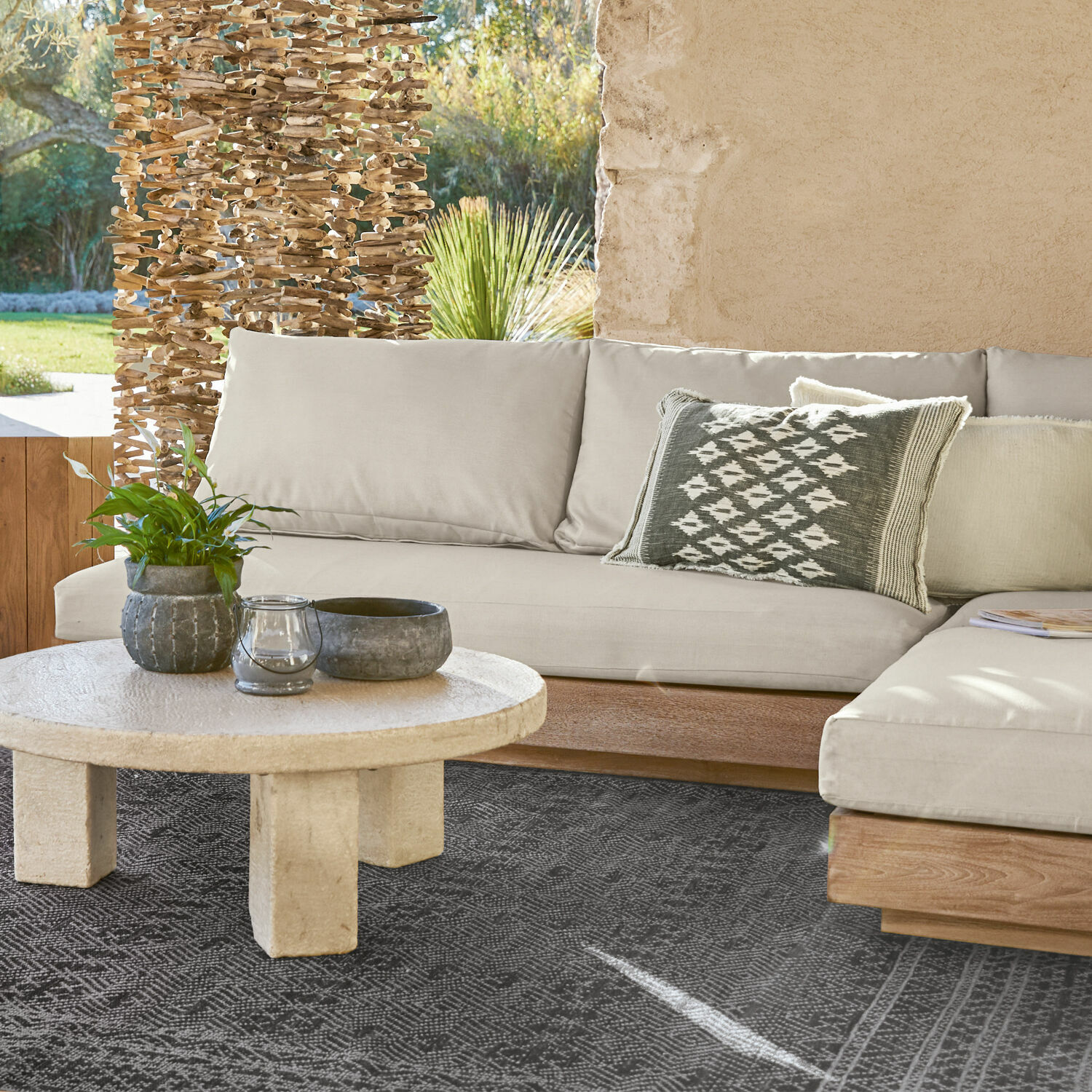 Sofaelement Courtelevant Beiges Sofa mit Holzuntergestell und dekorativem Kissen auf schwarzem Teppich im Wohnzimmer.
