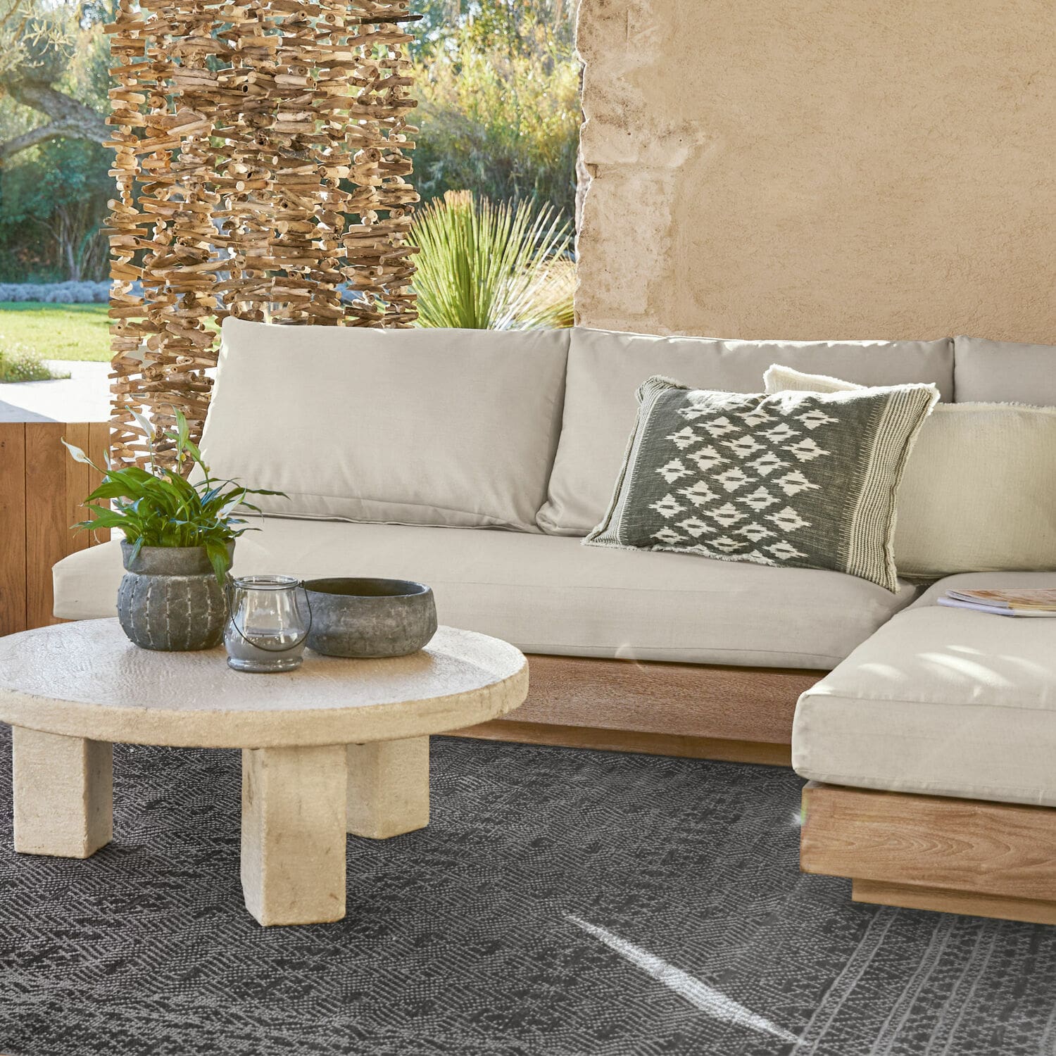 Sofaelement Courtelevant Beiges Sofa mit Holzuntergestell und dekorativem Kissen auf schwarzem Teppich im Wohnzimmer.