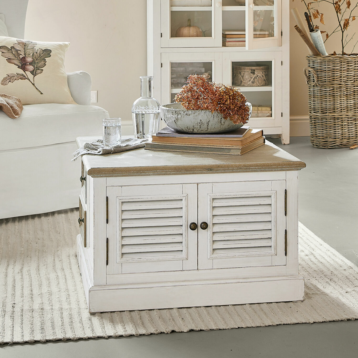 Couchtisch Cloverport Weisser Holzcouchtisch mit Schubladen und getrockneten Blumen als Dekoration im Wohnzimmer