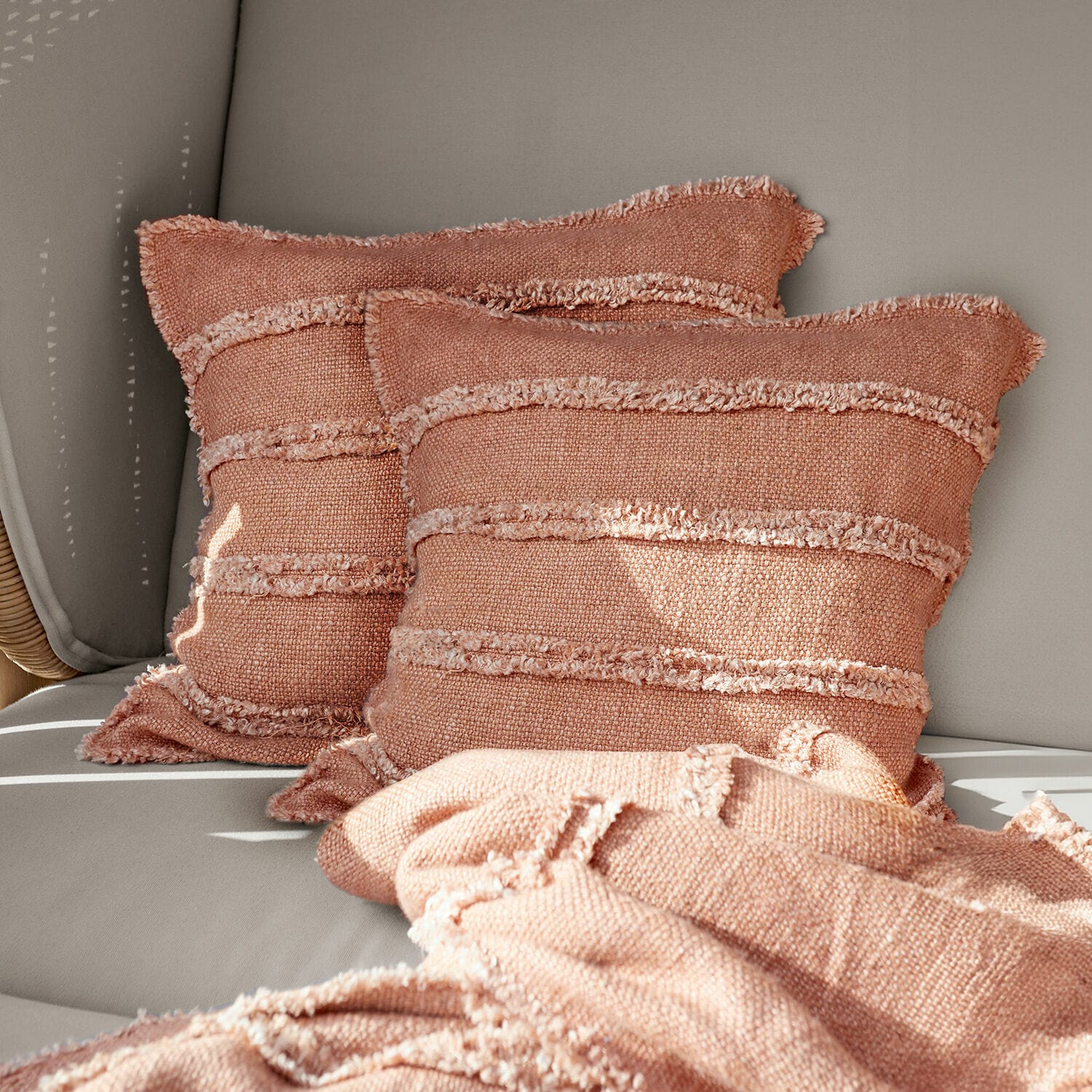 Kissenhülle 2er Set Allanton Rosa dekorative Kissen und weiche Stoffdecke auf grauem Sofa im Wohnzimmer