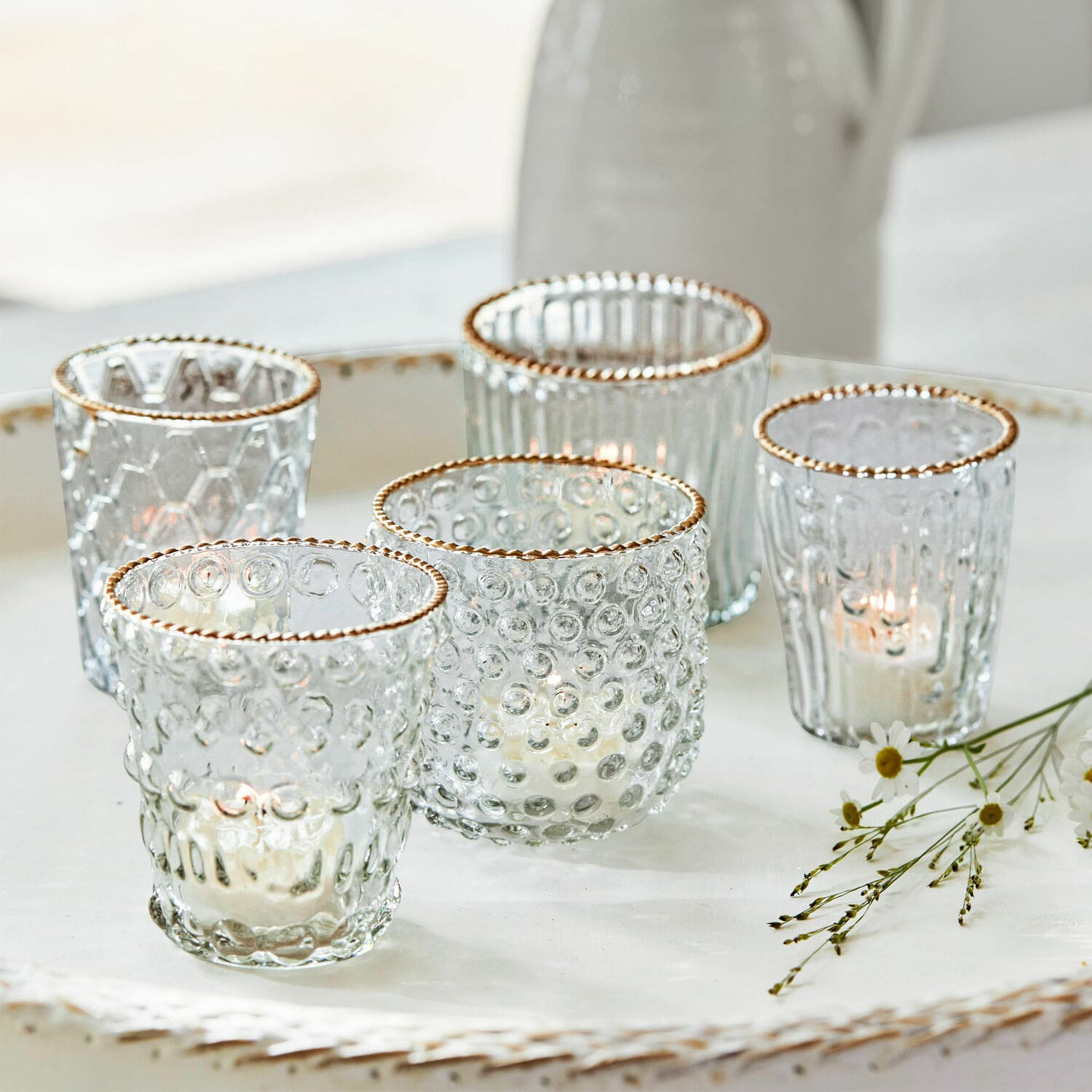 Windlicht 5er Set Jarnac Fünf Glas-Teelichthalter mit goldfarbenem Rand und Struktur auf weissem Dekotablett arrangiert