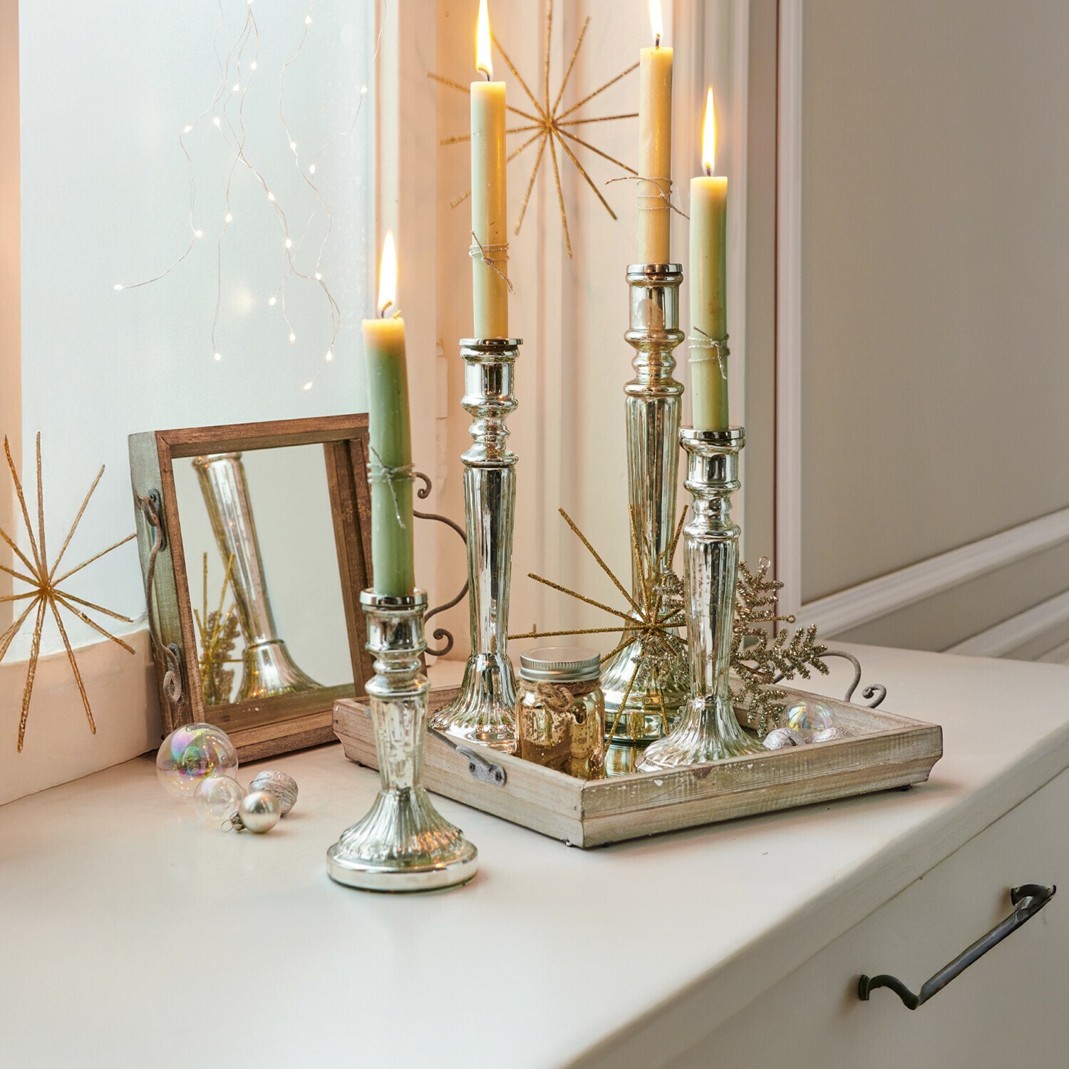 Kerzenständer 4er Set Selby Silberne Metallkerzenhalter mit grünen und cremefarbenen Kerzen auf dekorativem Holztablett
