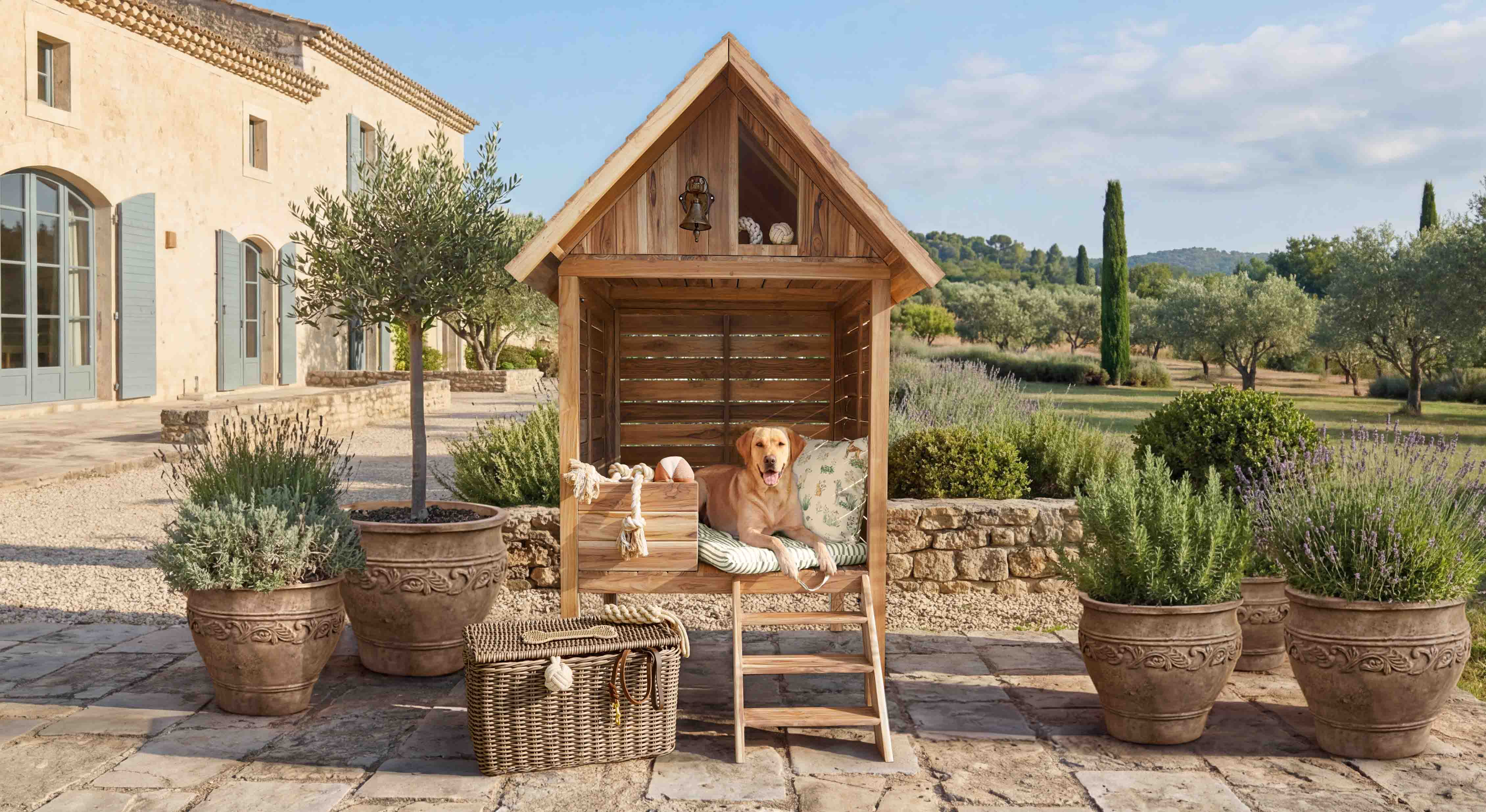 Holz-Hundehütte mit Kissen und Leiter auf Terrasse mit Pflanzen in Töpfen im Garten