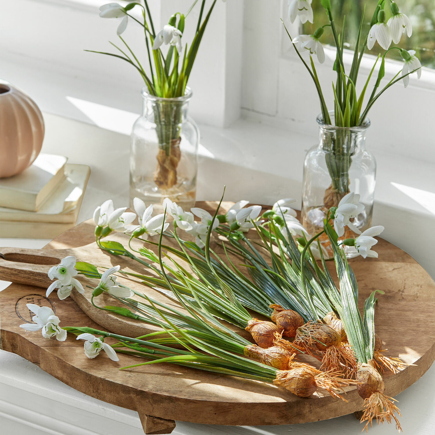 Deko-Blume 12er Set Willmare Weisse Schneeglöckchenblüten mit Zwiebeln auf einem Holzschneidebrett in einem hellen Raum