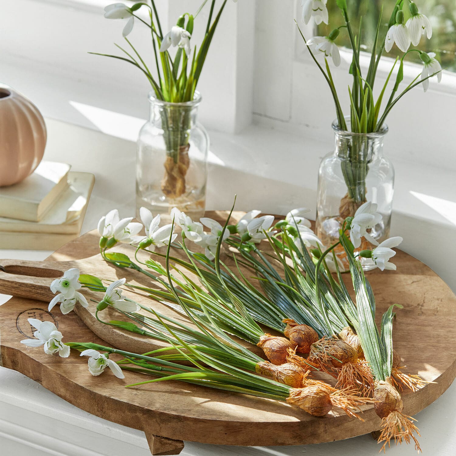 Deko-Blume 12er Set Willmare Weisse Schneeglöckchenblüten mit Zwiebeln auf einem Holzschneidebrett in einem hellen Raum