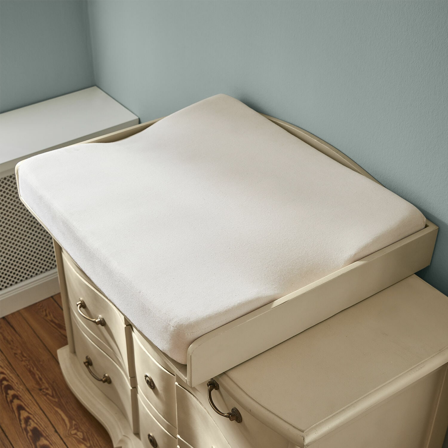 Wickelauflagenkissen Aiguillon Beige weiche Stoffauflage für den Wickeltisch auf dem cremefarbenen Kommodenschrank im Kinderzimmer