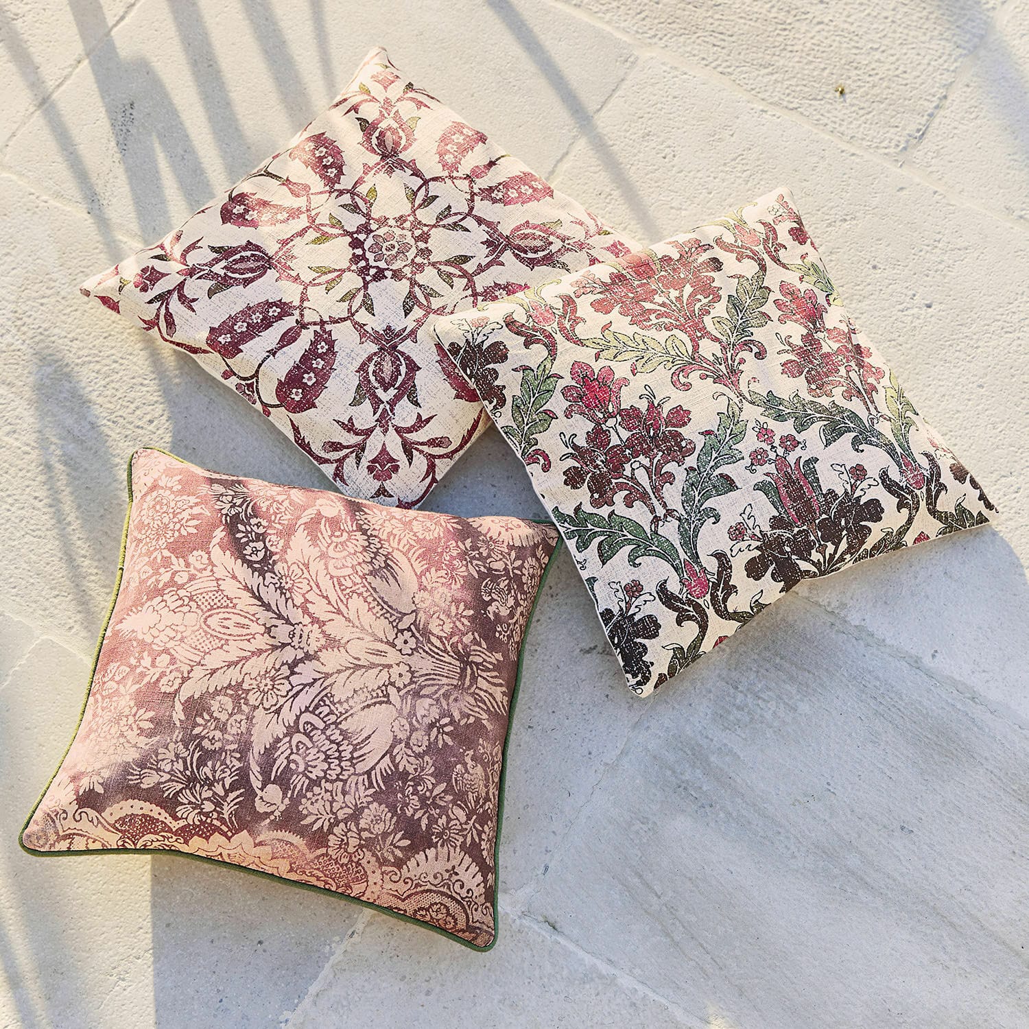 Kissenhülle 3er Set Camden Drei dekorative Baumwollkissen mit floralen Mustern in Rosa- und Grüntönen auf hellem Grund.