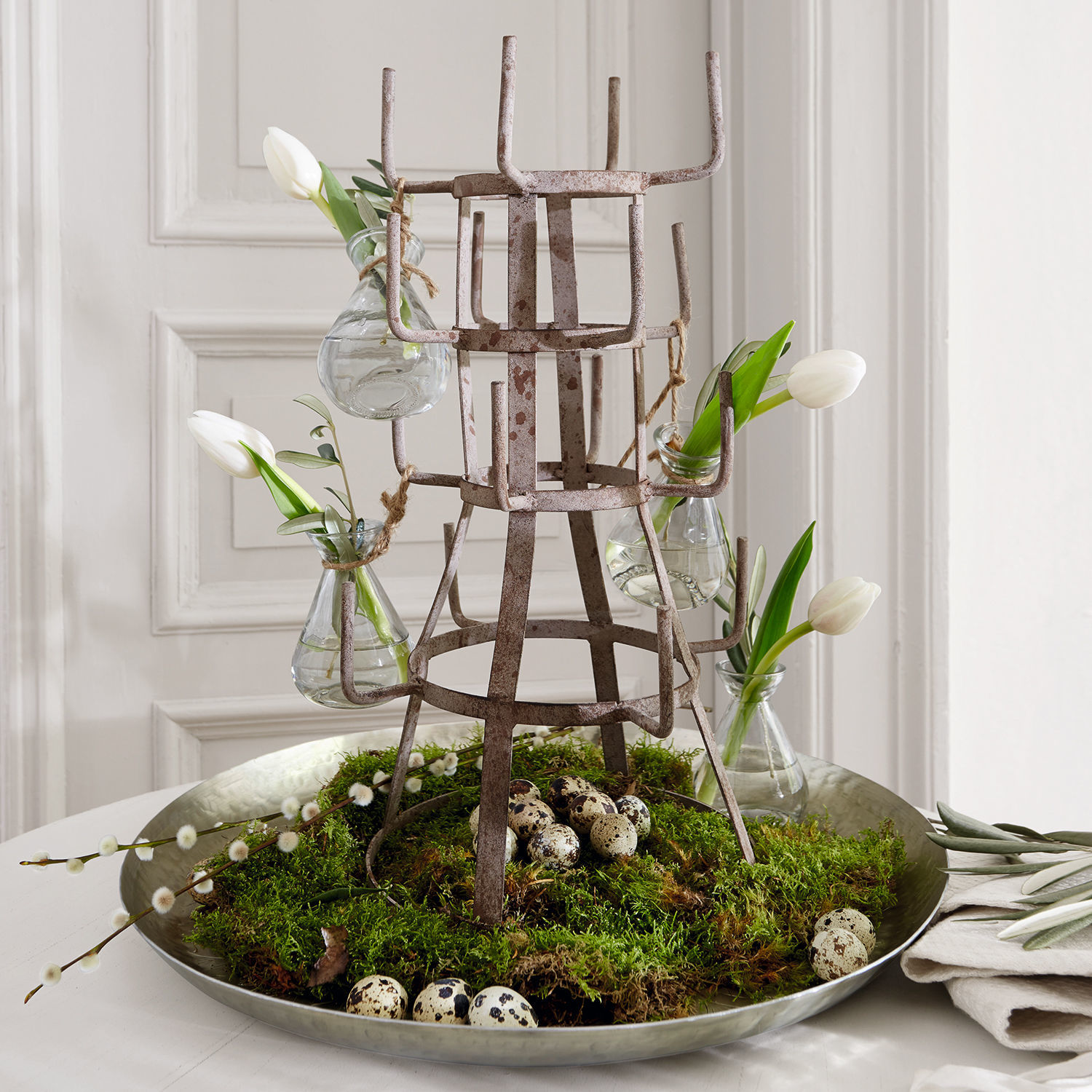 Metall-Dekoration mit kleinen Vasen und weissen Tulpen auf Tablett mit Moos und Wachteleiern