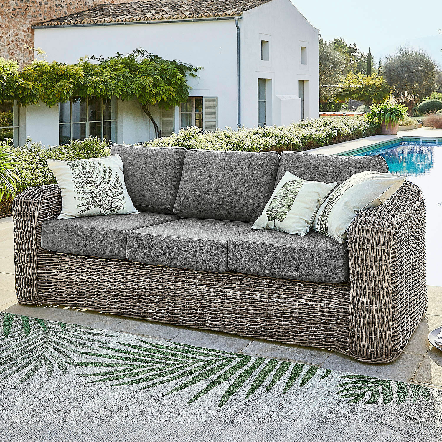 Sofa Upminster Gartensofa aus grauem Geflecht mit grauen Polstern und dekorativen Kissen mit Blattmotiven