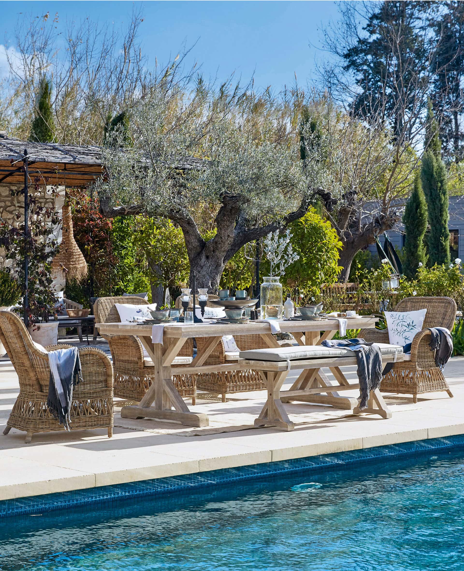 Gartenmöbel-Set aus Holz und Rattan in Naturtönen am Pool auf der Terrasse