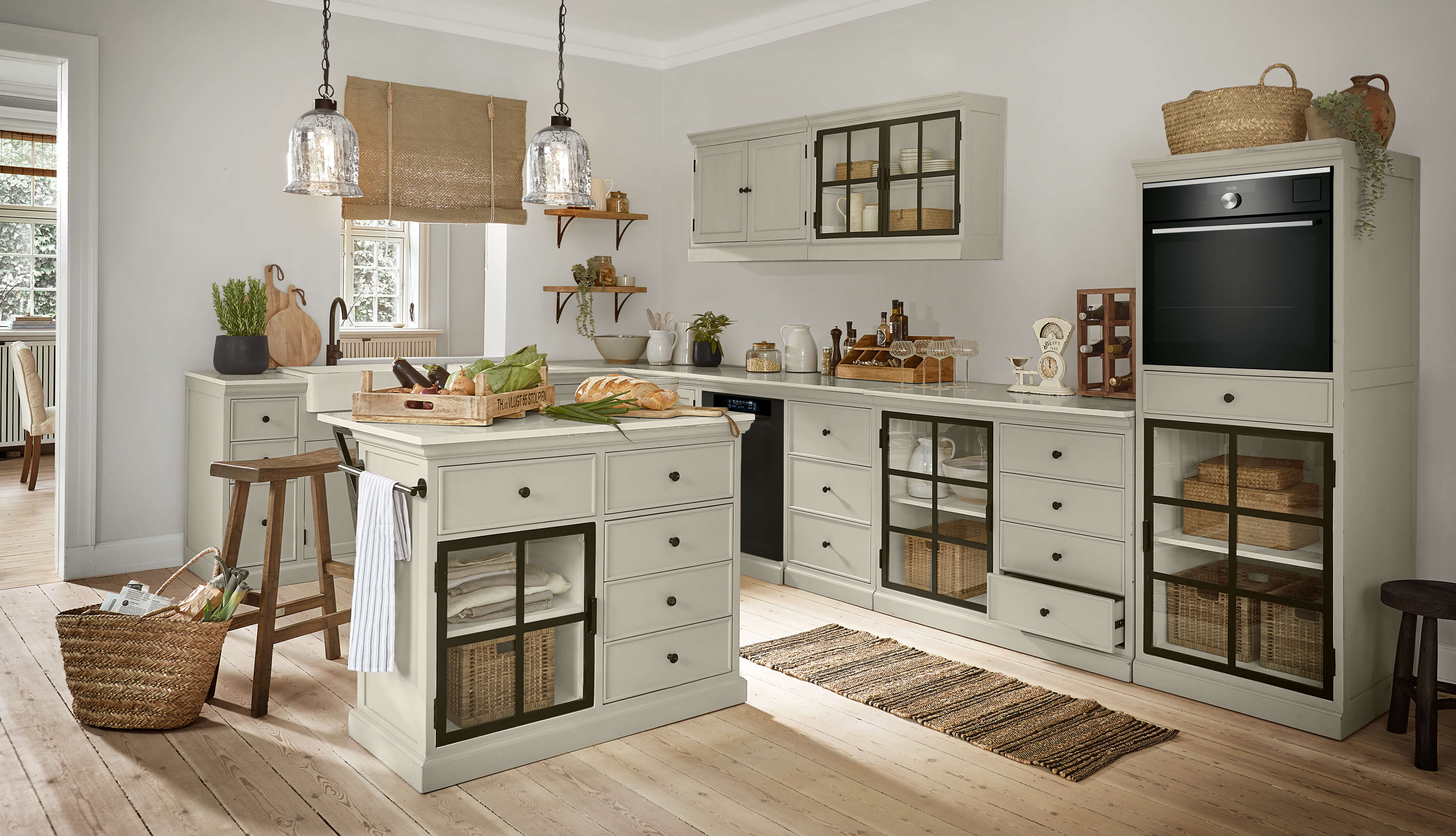 Rustikale Küche mit grauen Holzschränken und schwarzen Glastüren, hellem Holzboden und Landhausstil