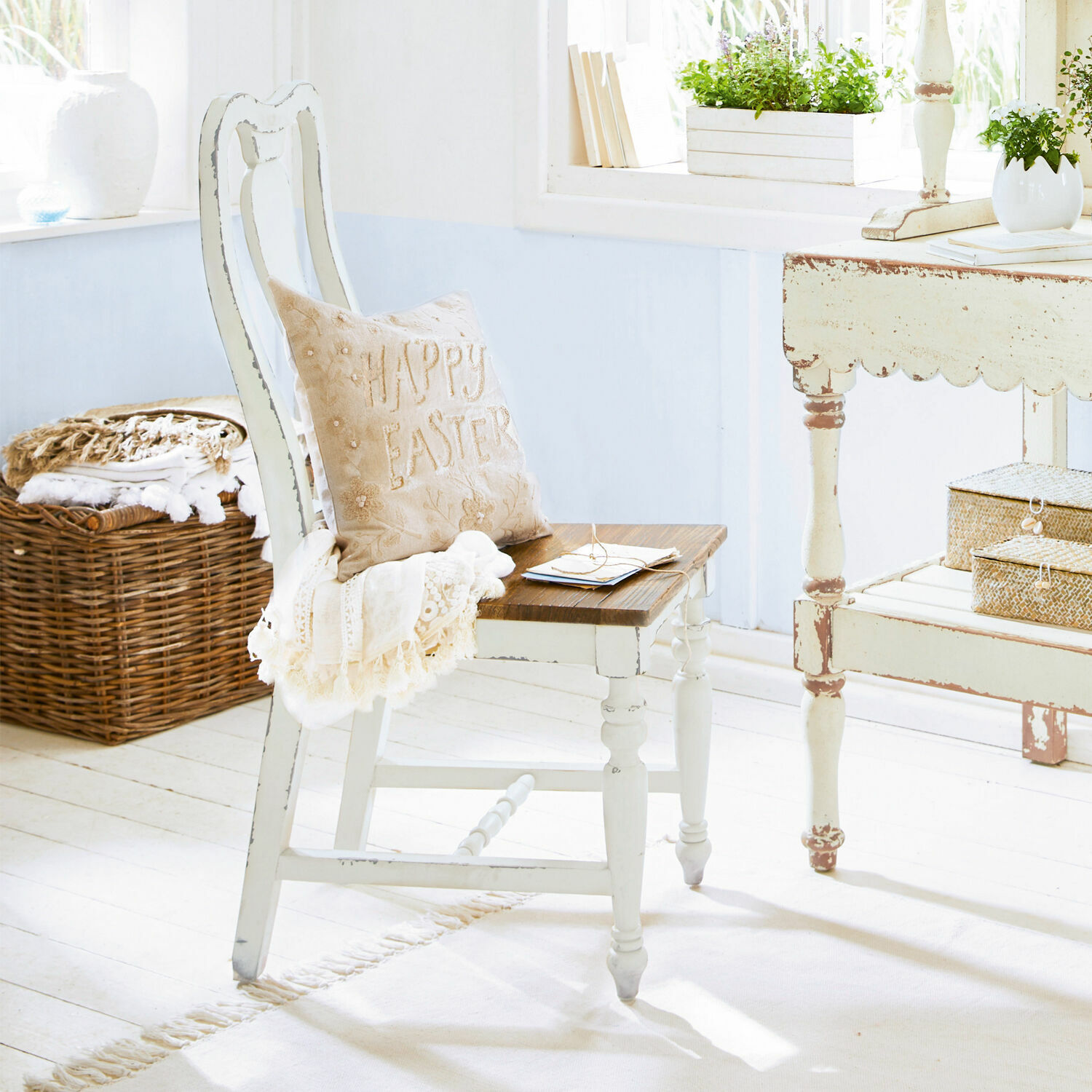 Stuhl Harry Weisser Holzstuhl mit braunem Sitz und beigem Happy-Easter-Kissen in hellem Raum