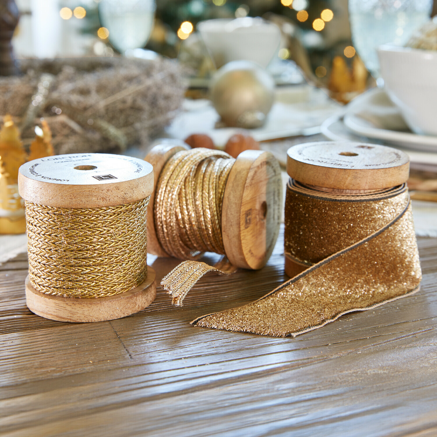 Band 3er Set Tamsworth Drei goldene Dekobänder auf Holzspulen auf festlich dekoriertem Tisch mit Weihnachtsdekoration