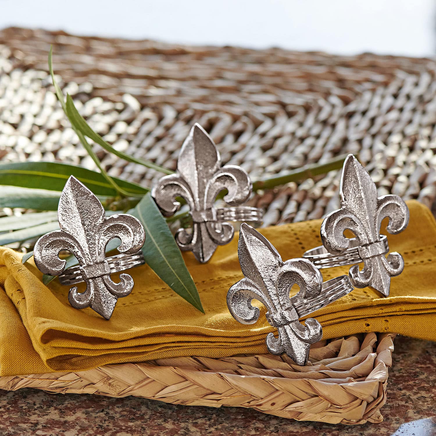 Serviettenring 4er Set Fleur De Lis Silberne Metall-Serviettenringe mit Lilienmotiv auf gelbem Stoff und geflochtenem Tablett