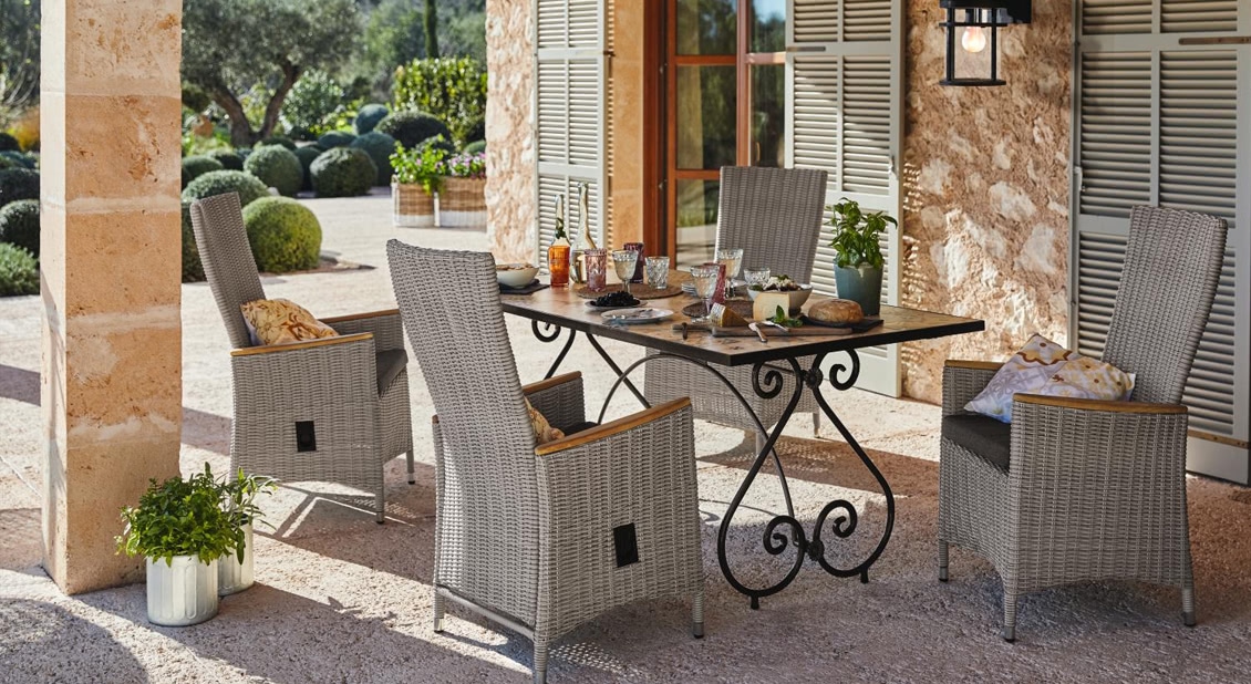 Gartenmöbel-Set mit grauen Rattanstühlen und Holztisch mit schwarzen Metallbeinen im Aussenbereich