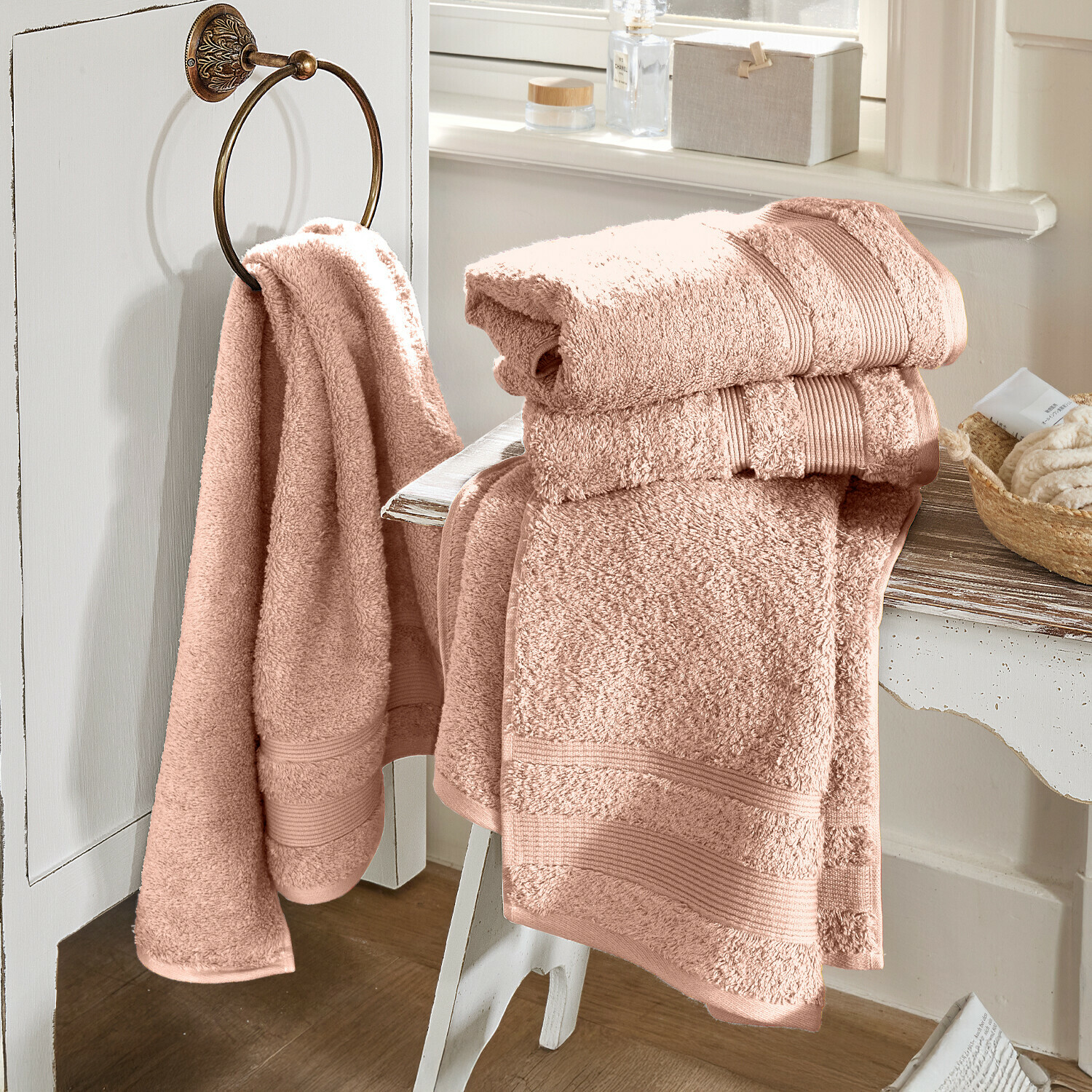 Rosa Baumwoll-Badetücher auf weissem Möbel in hellem Badezimmer, weich und saugfähig