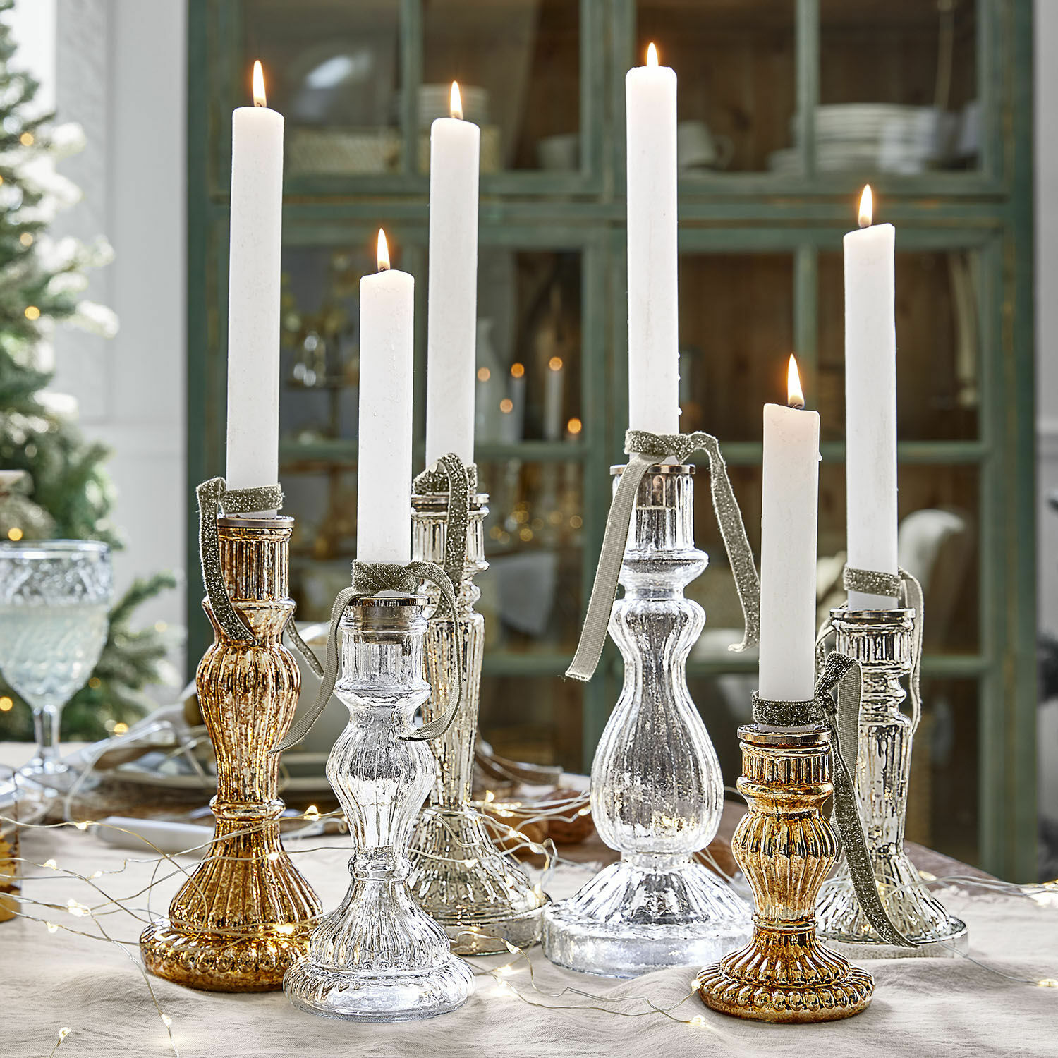 Kerzenständer 6er Set Quirène Set aus gold- und silberfarbenen Glas-Kerzenhaltern mit weissen Kerzen auf festlich gedecktem Tisch