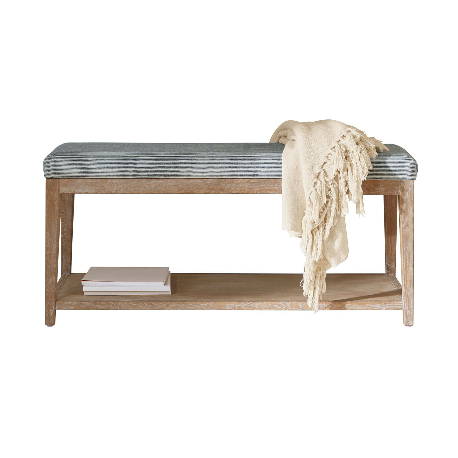 Bank aus hellem Holz mit blau-weiß gestreiftem Polster und cremefarbenem Überwurf, praktische Sitzgelegenheit