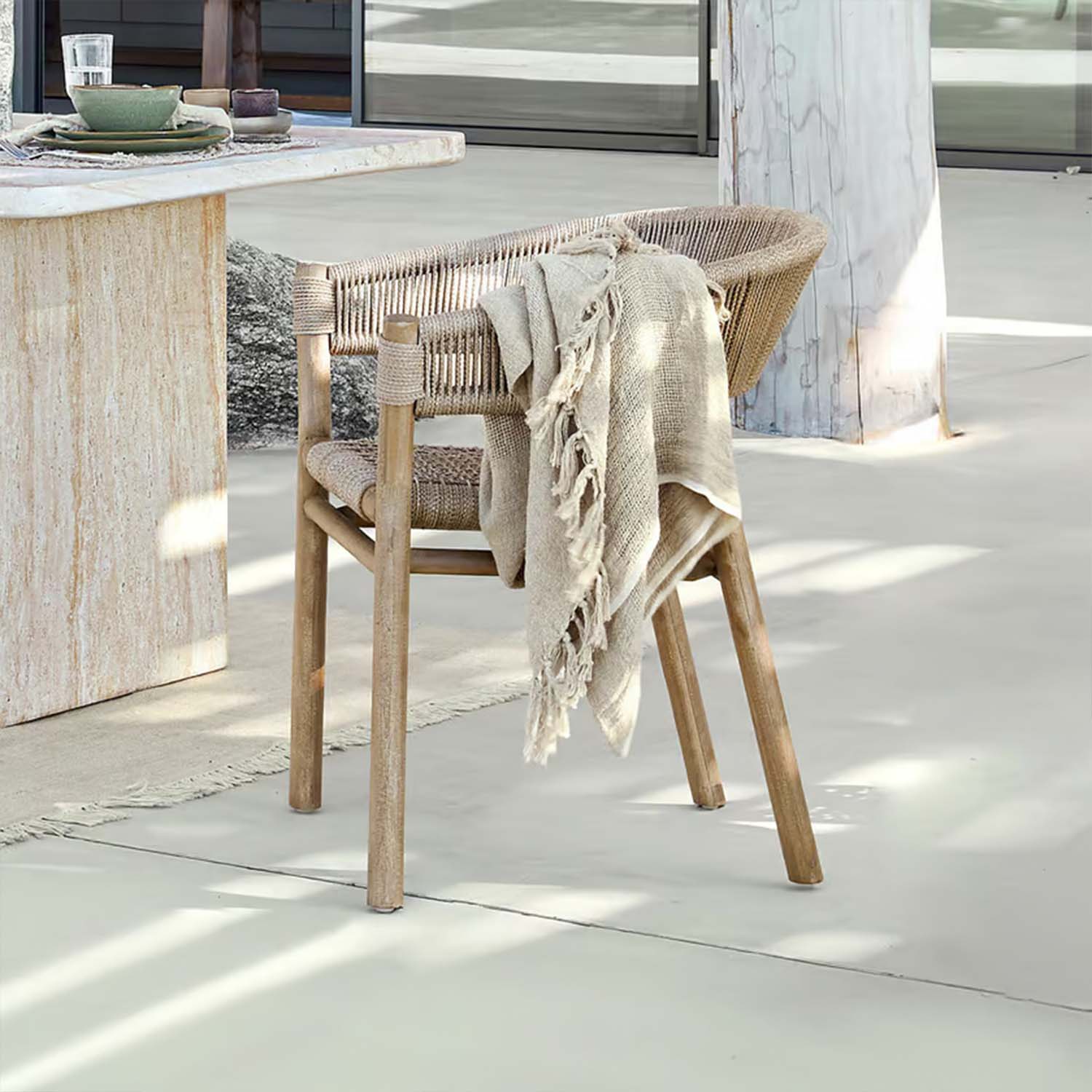 Stuhl aus Holz und geflochtenem Material in Naturtönen mit beiger Decke, moderner Outdoor-Stuhl