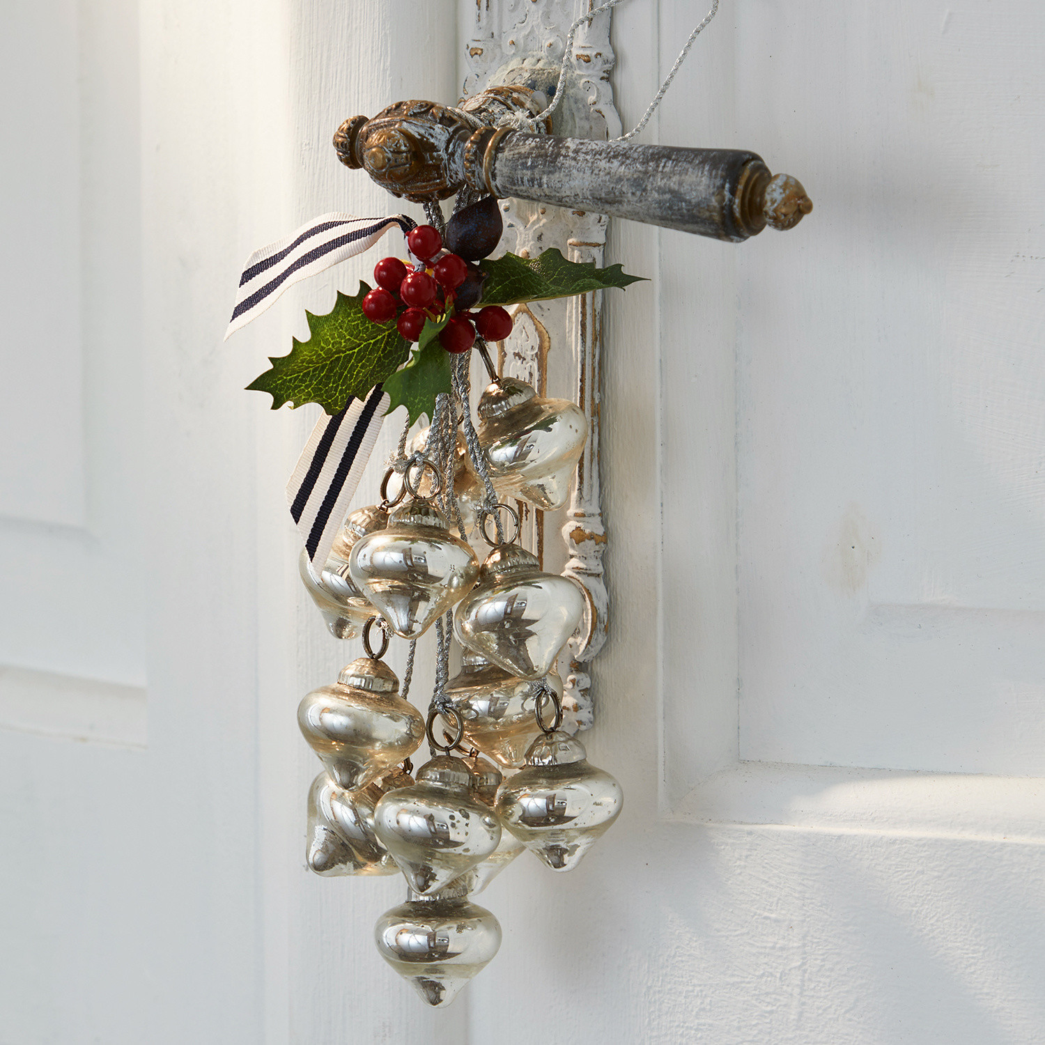 Weihnachtsschmuck Sassey Weihnachtsschmuck aus silbernem Glas mit roten Beeren an weisser Türe hängend