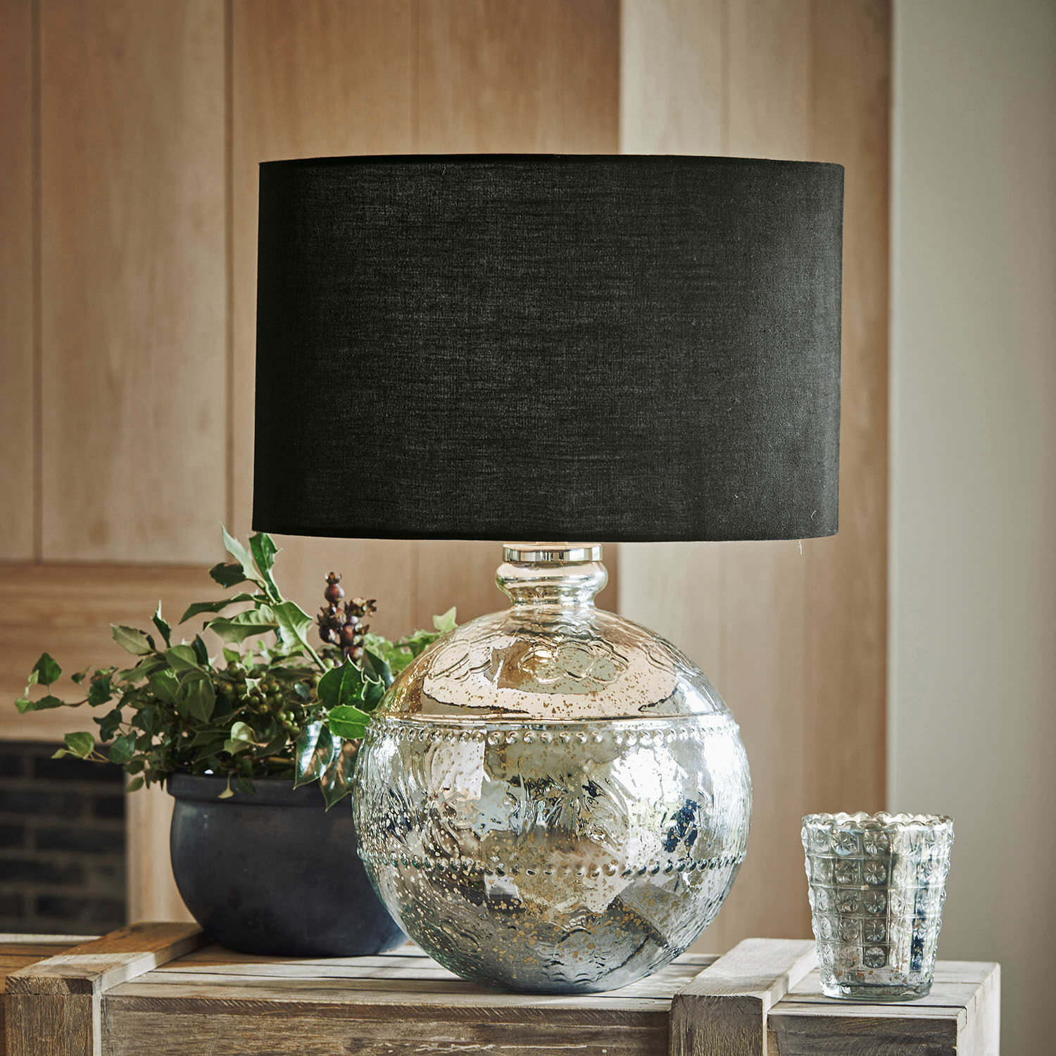 Tischlampe Voyer Dekorative Tischlampe mit silbernem Glasfuss und schwarzem Lampenschirm auf Holztisch