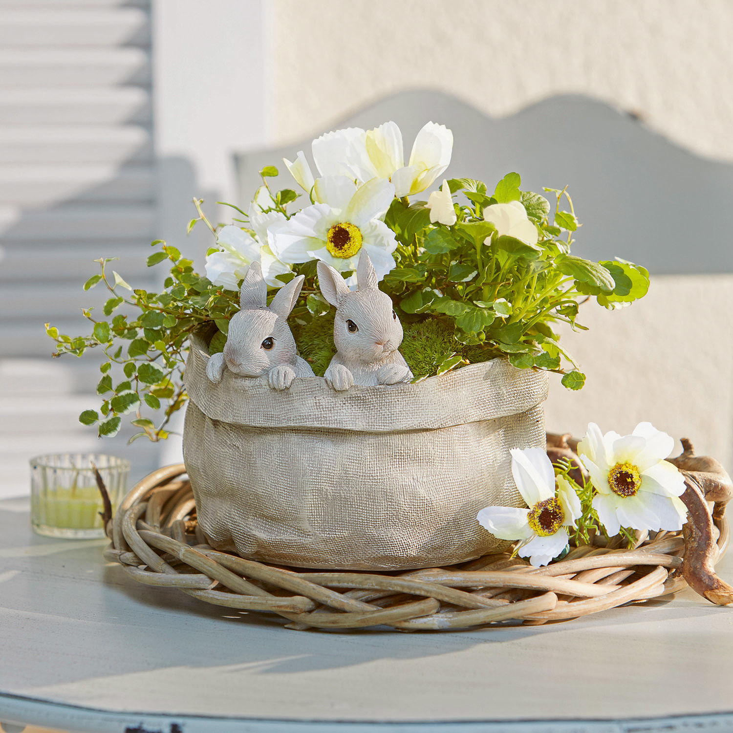 Übertopf Mouriel Dekorativer Stoff-Topfbeutel in Beige mit weissen Blumen und Hasenfiguren auf einem Weidenkorb