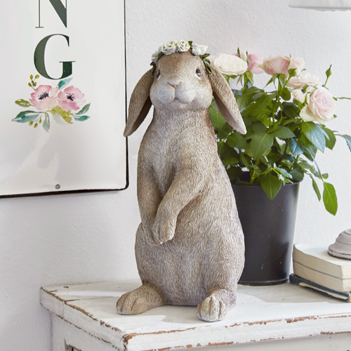 Beige Hasenfigur aus Kunststoff mit Blumenkranz als dekoratives Wohnaccessoire