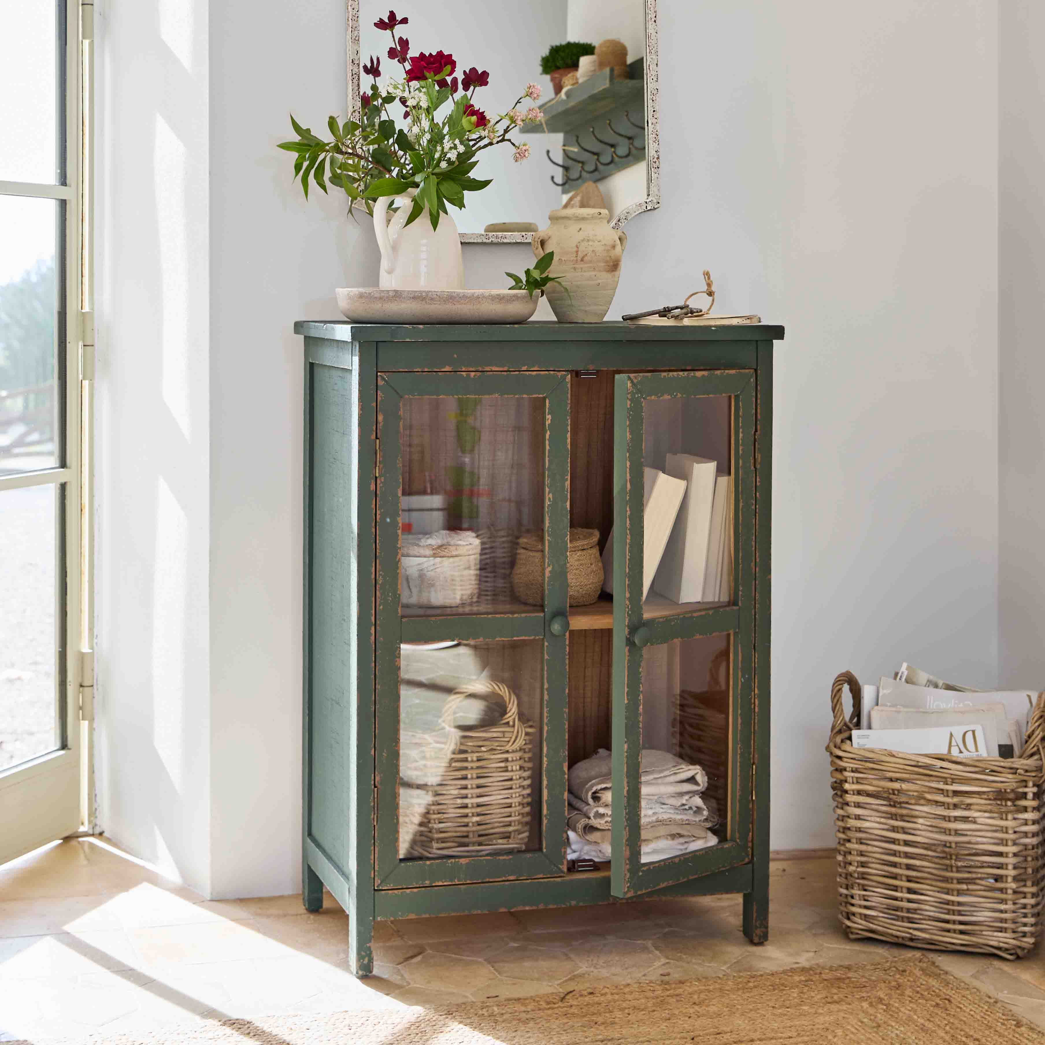 Grüner Holzschrank mit Glastüren und dekorativen Vasen auf der Ablage im Vintage-Stil