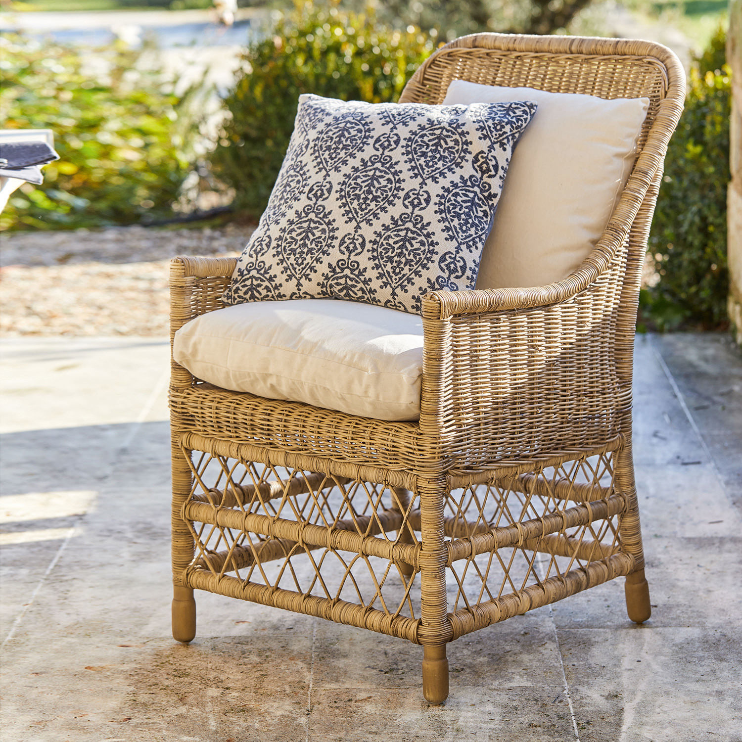 Sessel Giepmare Rattansessel mit cremefarbenen Polstern und blau gemustertem Zierkissen, Gartenmöbel im Aussenbereich