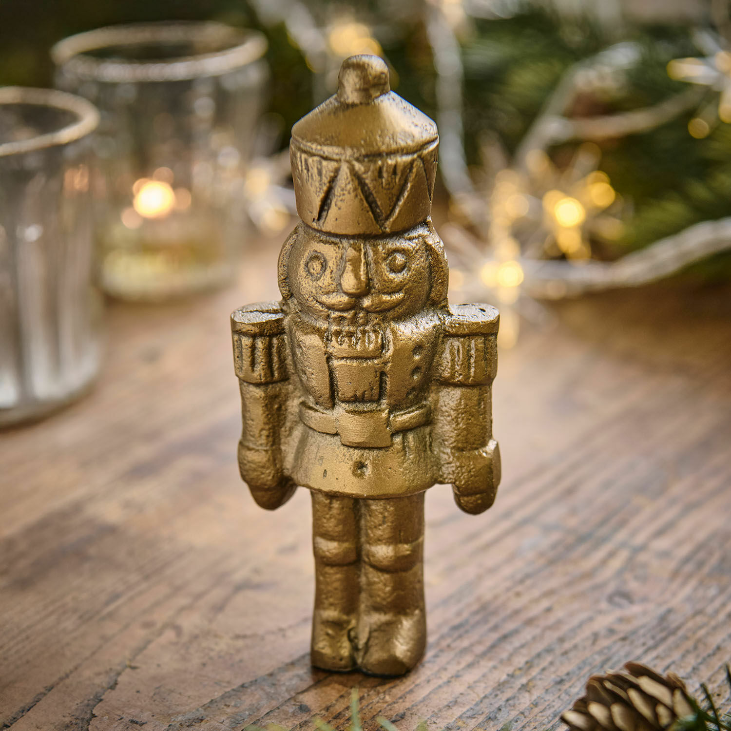 Deko-Figur Zarilith Goldfarbener Metall-Nussknacker auf Holztisch, festliche Weihnachtsdekoration